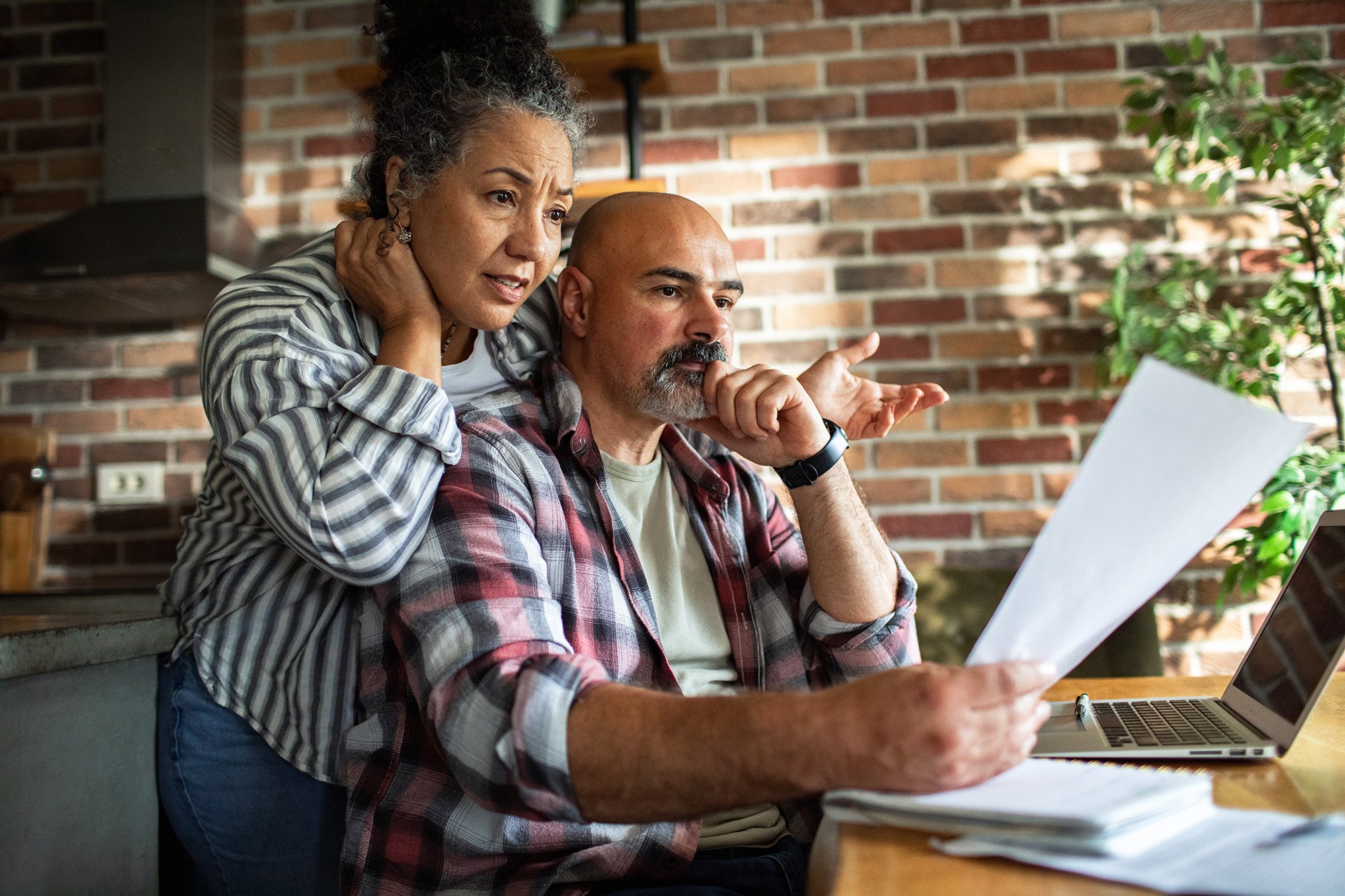 Concern middle-aged couple reading a document together