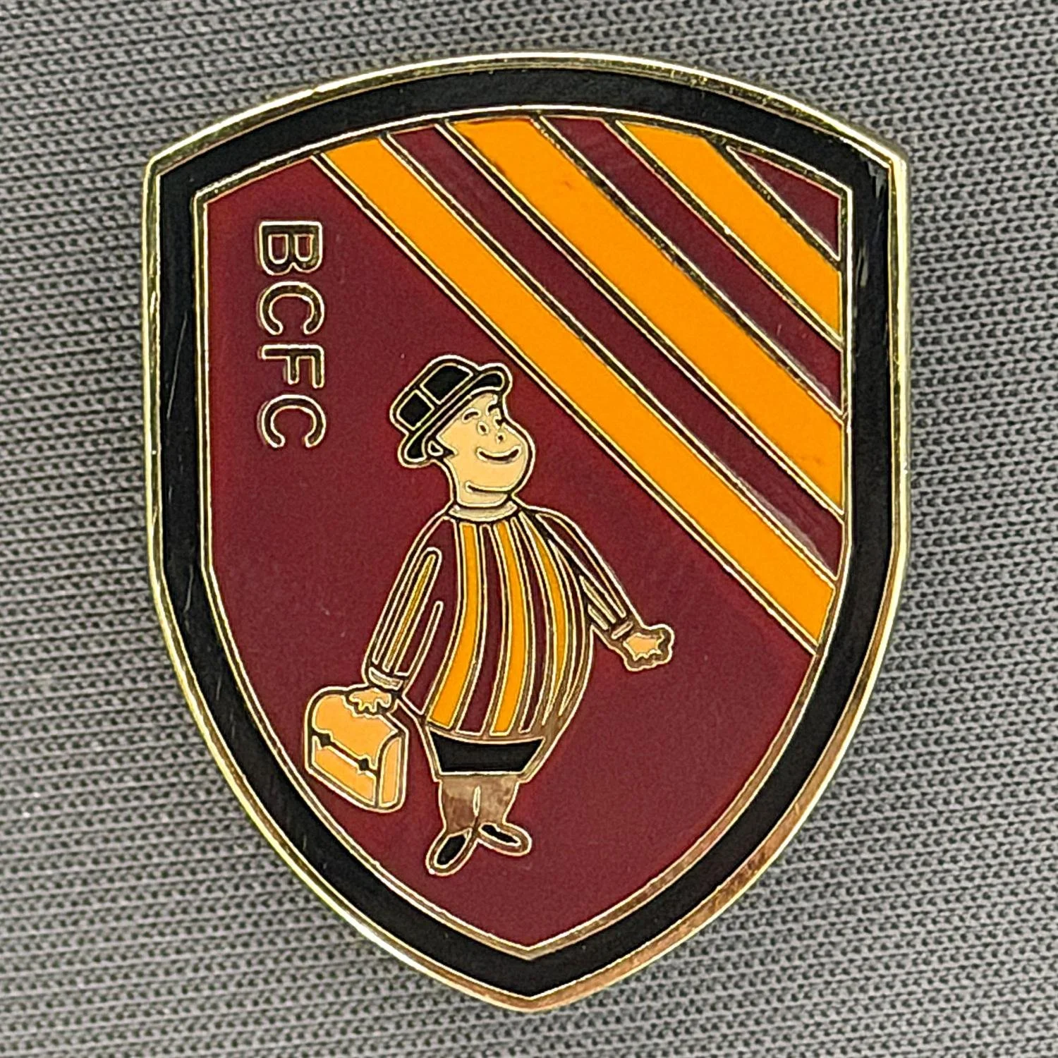 Reference Number: BCGEN109
Size: H 27.9 mm x W 22.2 mm
Pin Type: Brooch Pin
Plating: Gold
Value: £6
Manufacturer: Unknown
Comments: City Gent Shield, Claret & Amber 