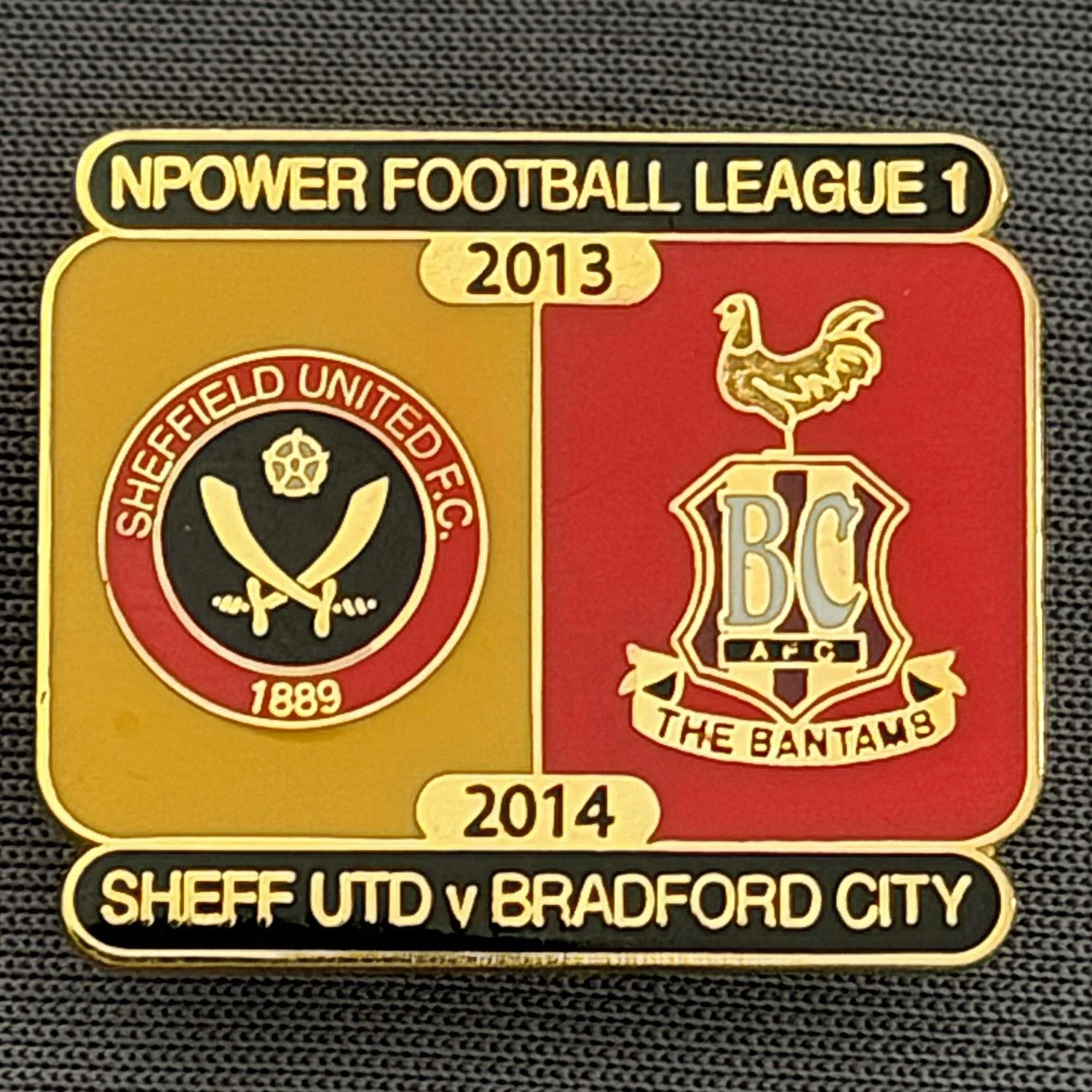 Reference Number: BCOFIX075
Size: H 21.7 mm x W 25.6 mm
Pin Type: Brooch Pin
Plating: Gold
Value: £5
Manufacturer: Unknown
Comments: Sheffield United v Bradford City, League One, Amber & Red Version