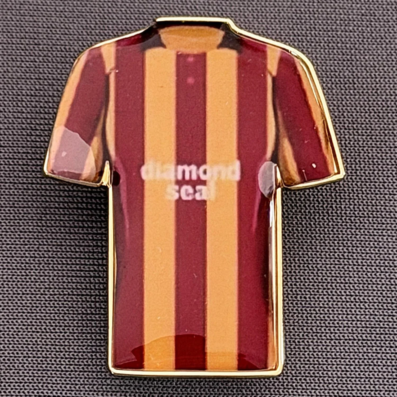 Reference Number: BCKIT094
Size: H 33 mm x W 27.1 mm
Pin Type: Metal Clutch
Plating: Gold
Value: £4
Manufacturer: Blue Badge Design
Comments: Bradford City 1994/96 Home Kit, Plastic Dome
