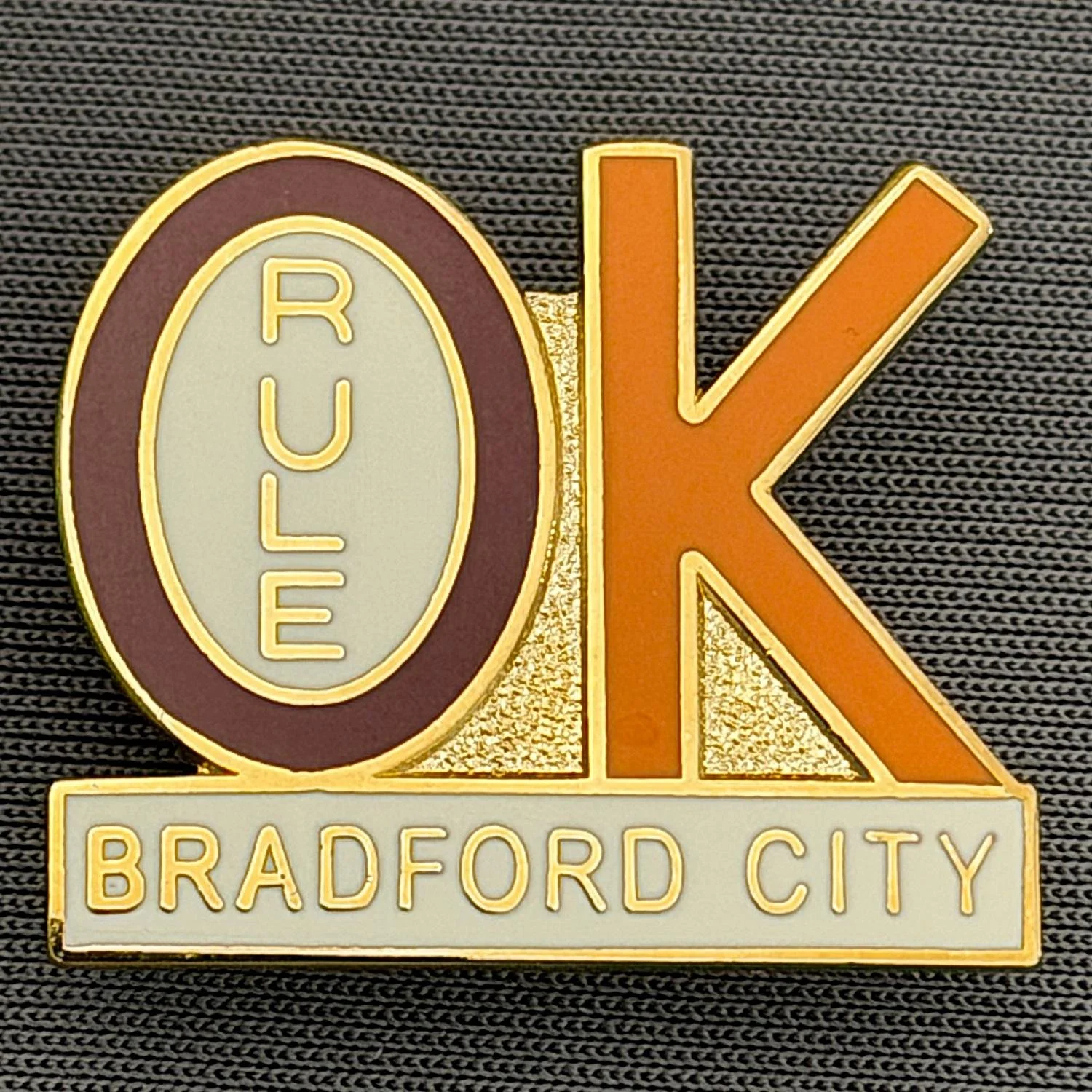 Reference Number: BCBCFC046
Size: H 21.7 mm x W 25.3 mm
Pin Type: Brooch Pin
Plating: Gold
Value: £6
Manufacturer: Paraders
Comments: Bradford City Rule OK, Claret & Amber Version, Copy of Original Version