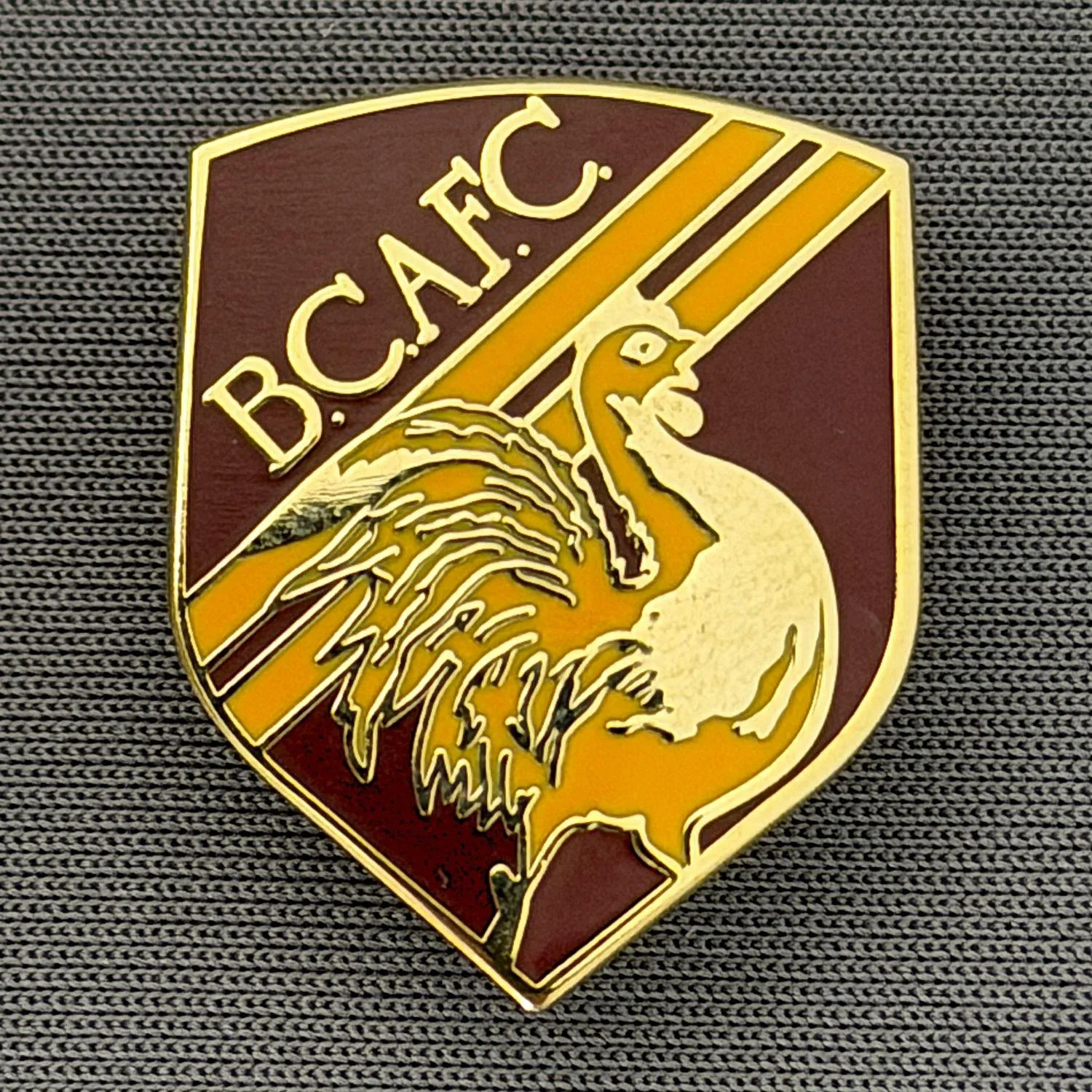 Reference Number: BCBAN048
Size: H 24.1 mm x W 19.4. mm
Pin Type: Brooch Pin
Plating: Gold
Value: £6
Manufacturer: Unknown
Comments: Claret & Amber Bantam Shield