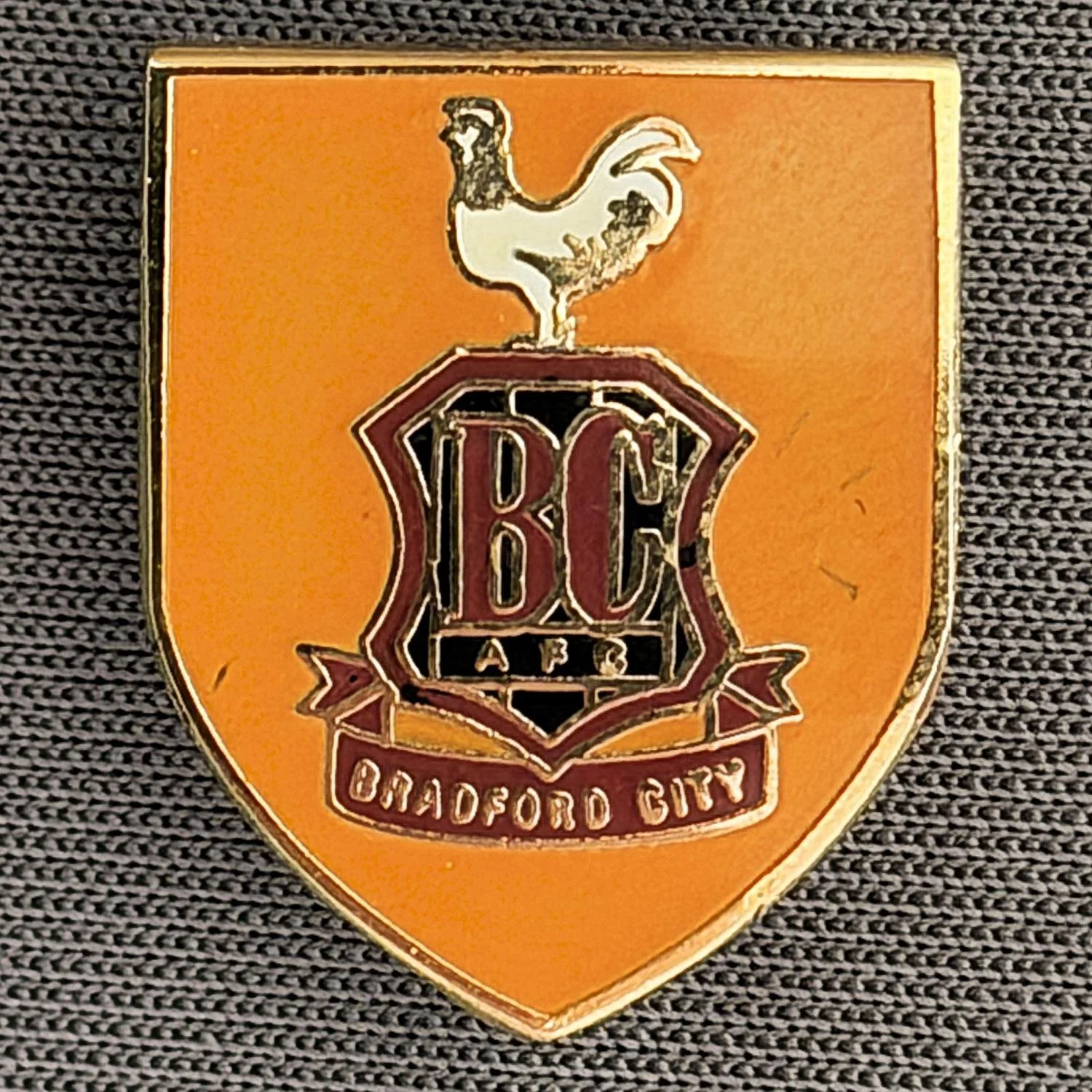 Reference Number: BCC&L023
Size: H 19 mm x W 15.6 mm
Pin Type: Brooch Pin
Plating: Gold
Value: £6
Manufacturer: Unknown
Comments: Amber City Logo Shield