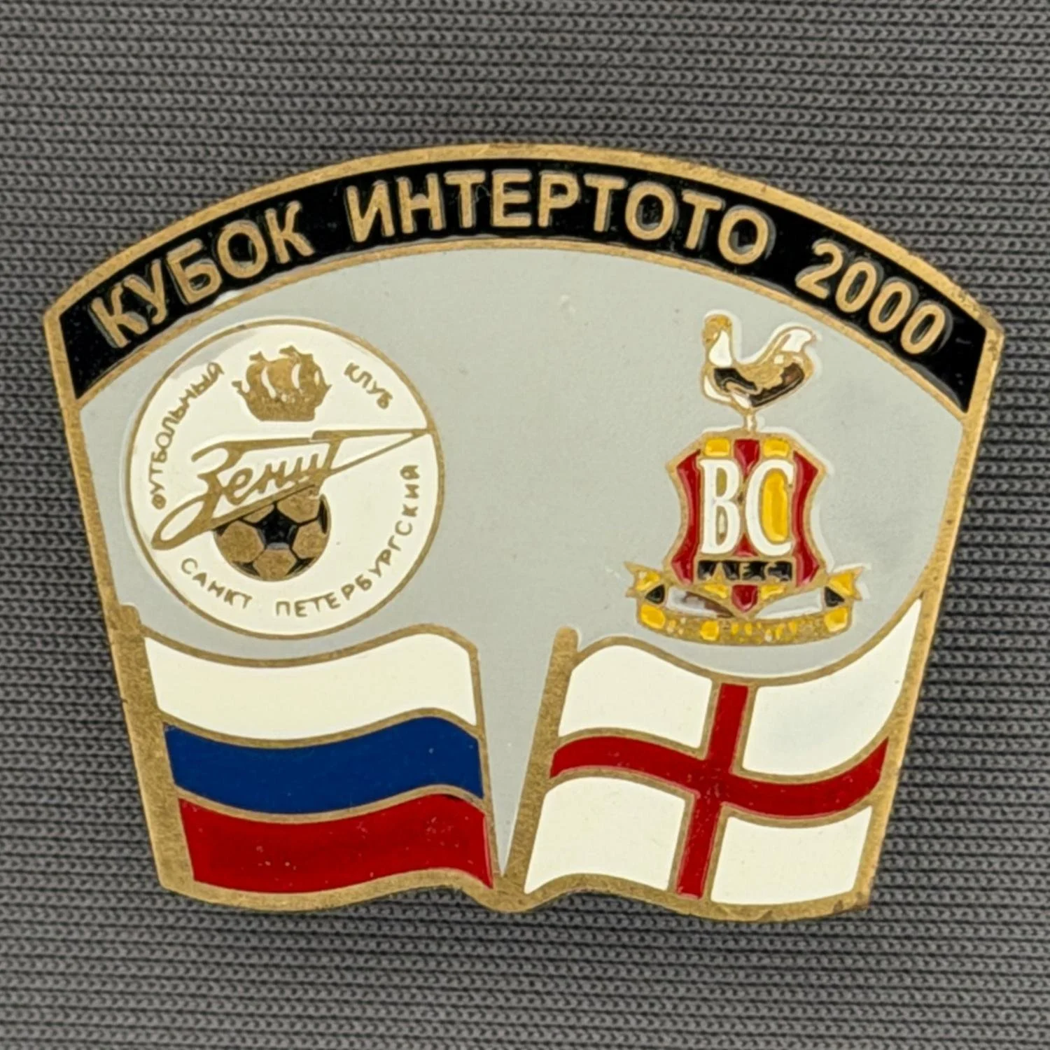 Reference Number: BCRUS030
Size: H 26 mm x W 32.3 mm
Pin Type: Metal Clutch
Plating: Antique Gold
Value: £12
Manufacturer: Unknown
Comments: Zenit St. Petersburg Inter Toto Cup, Black Top, Grey Background