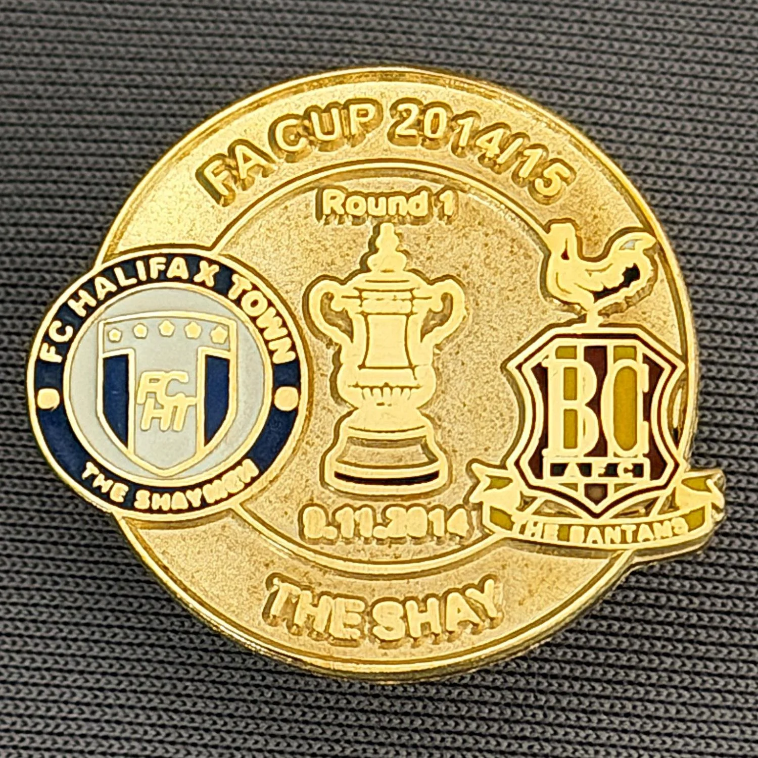 Reference Number: BCFAC062
Size: H 22. 7 mm x W 25.8 mm
Pin Type: Metal Clutch
Plating: Gold
Value: £4
Manufacturer: Dan Lloyd
Comments: F.A. Cup 2014/15 Away v Halifax Town, Gold Version