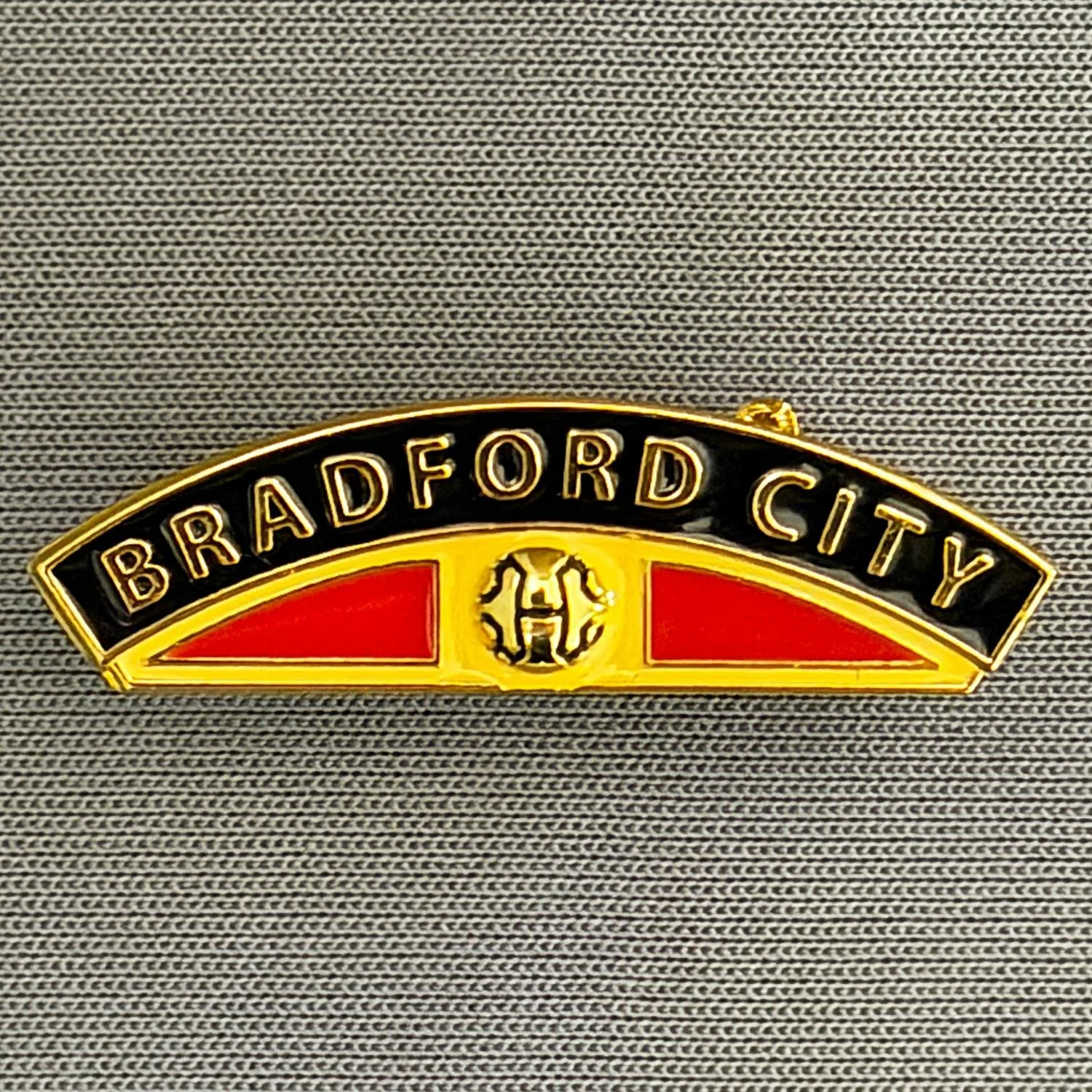 Reference Number: BCBCFC056
Size: H 8.7 mm x W 30 mm
Pin Type: Brooch Pin
Plating: Gold
Value: £6
Manufacturer: Unknown
Comments: Bradford City 3D Claret & Amber Railway Engine Nameplate 