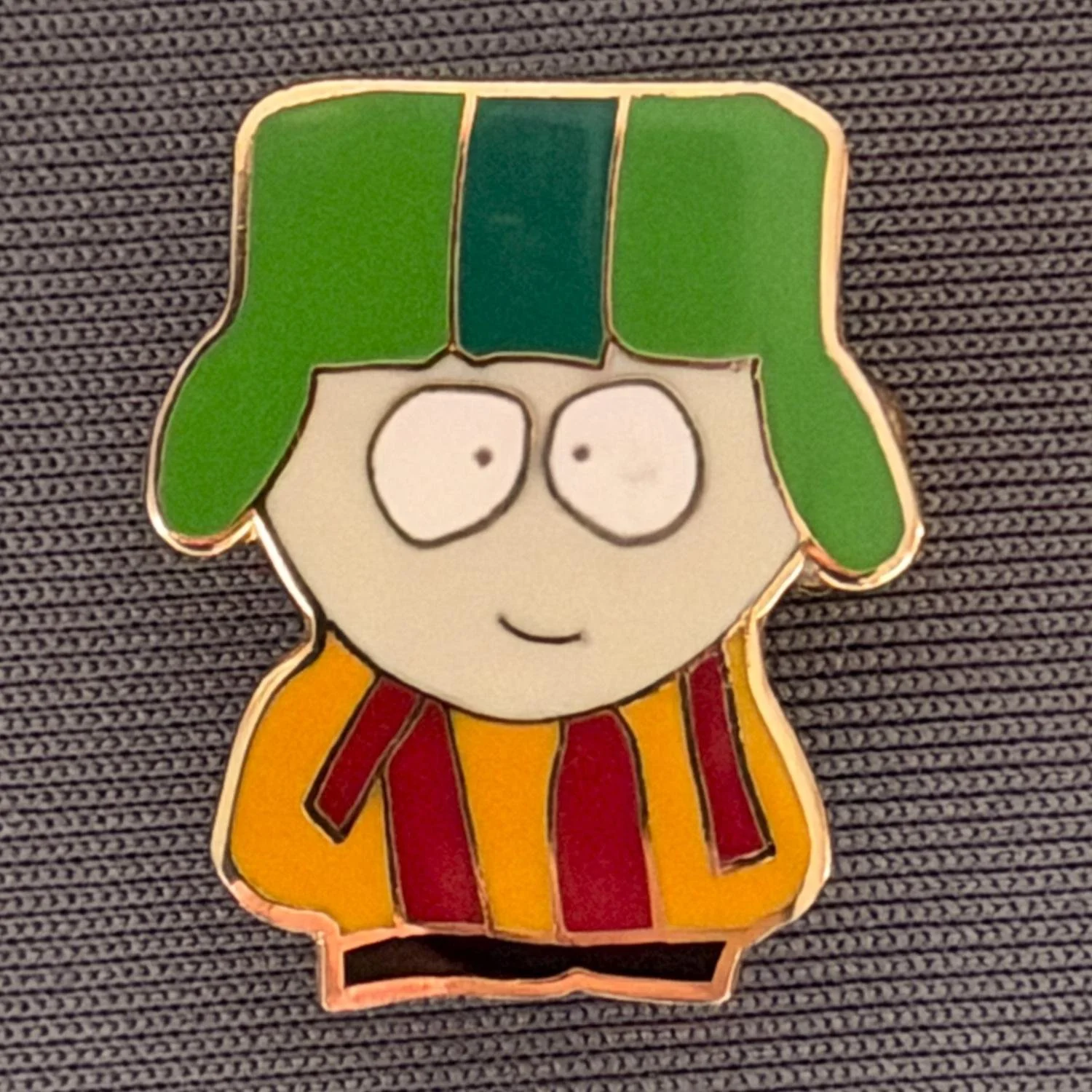 Reference Number: BCCTN029
Size: H 21.7 mm x W 18.1 mm
Pin Type: Brooch Pin
Plating: Gold
Value: £6
Manufacturer: Not Known
Comments: Kyle Broflovski South Park in Bradford City Kit Different Version