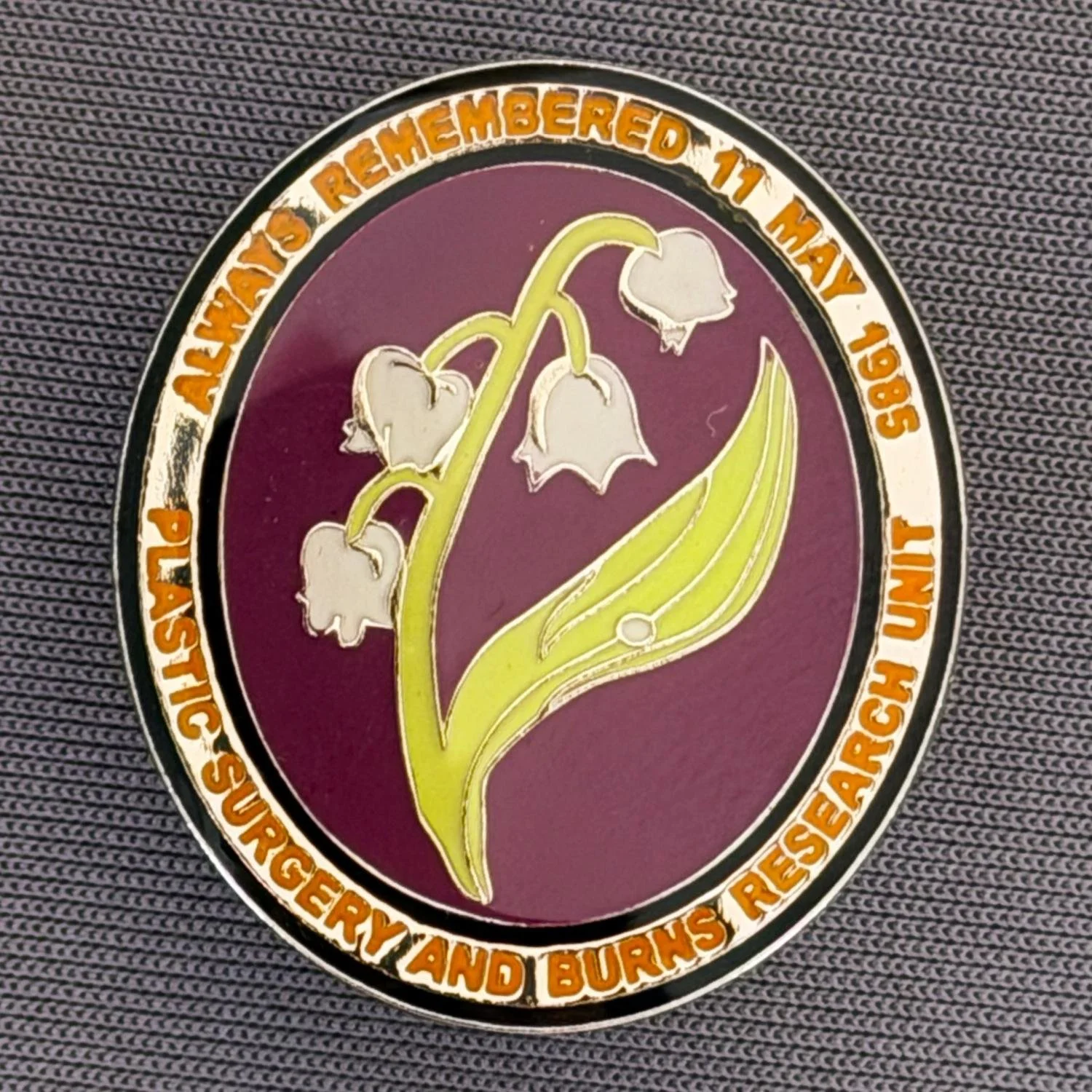 Reference Number: BCFIR013
Size: H 28.1 mm x W 24 mm
Pin Type: Metal Clutch
Plating: Silver
Value: £8
Manufacturer: PSBRU ?
Comments: Plastic domed badge with Lily of the Valley to raise money for the PSBRU