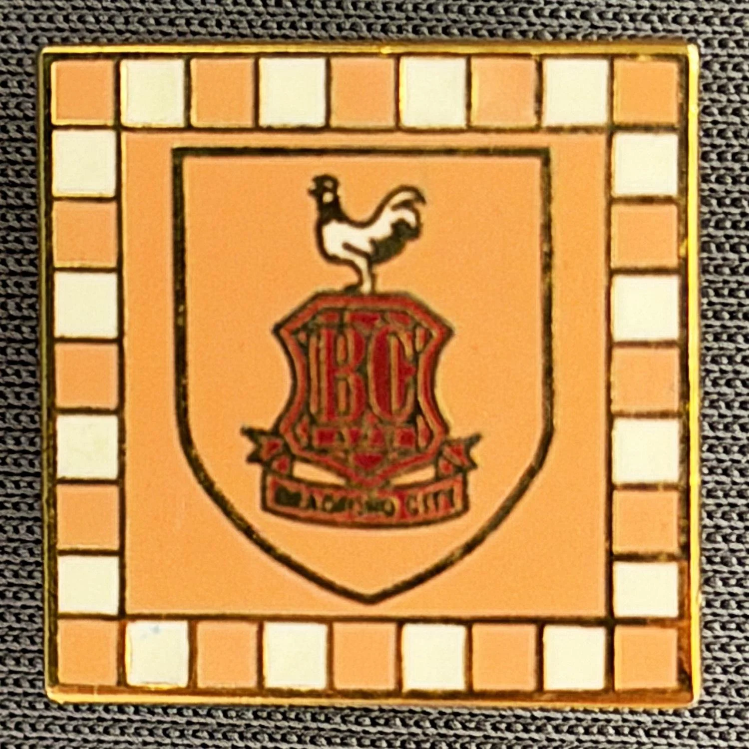 Reference Number: BCC&L016
Size: H 17.1 mm x W 17.1 mm
Pin Type: Brooch Pin
Plating: Gold
Value: £6
Manufacturer: Unknown
Comments: Amber & White Check City Logo