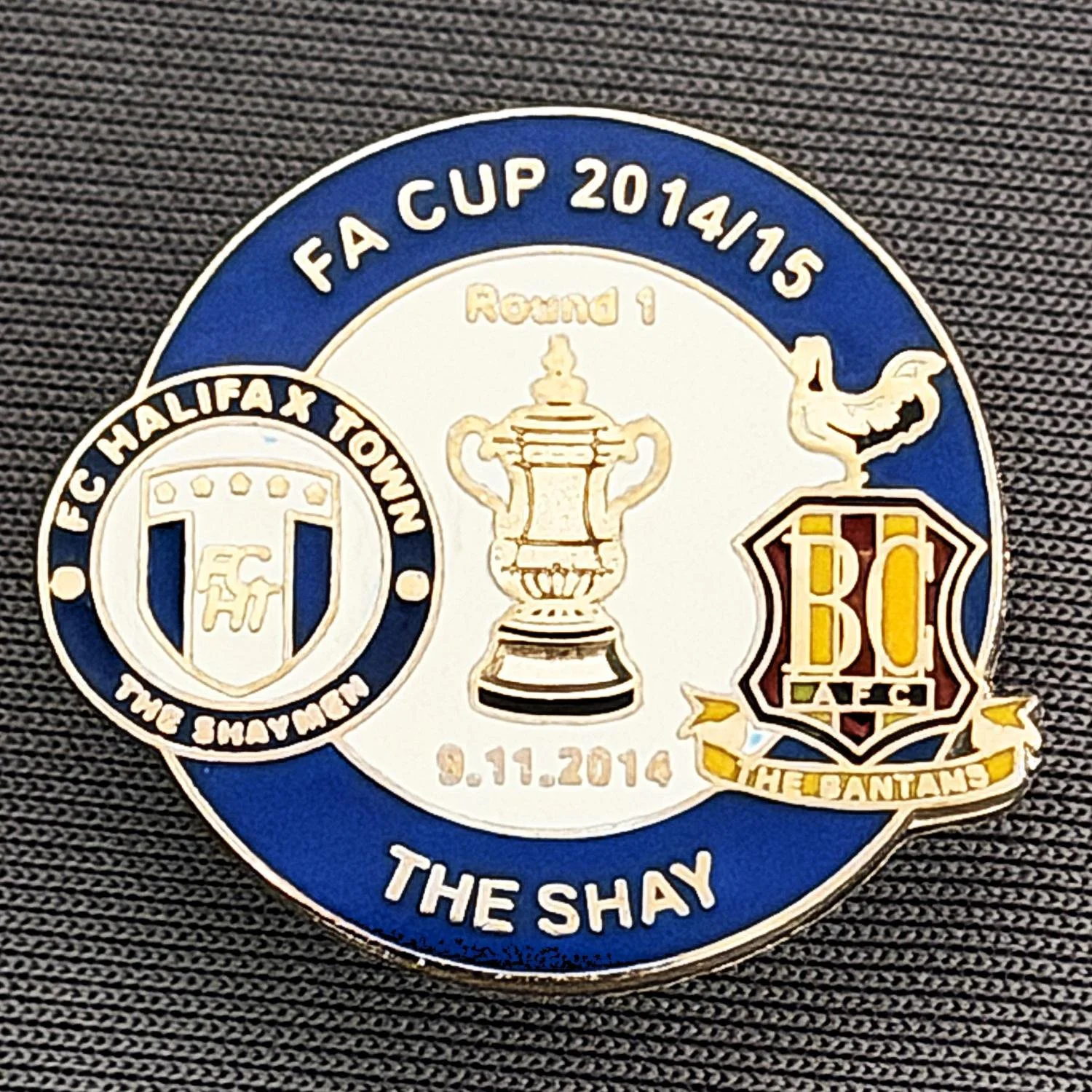 Reference Number: BCFAC057
Size: H 22. 7 mm x W 25.8 mm
Pin Type: Metal Clutch
Plating: Silver
Value: £4
Manufacturer: Dan Lloyd
Comments: F.A. Cup 2014/15 Away v Halifax Town, Blue & White Version