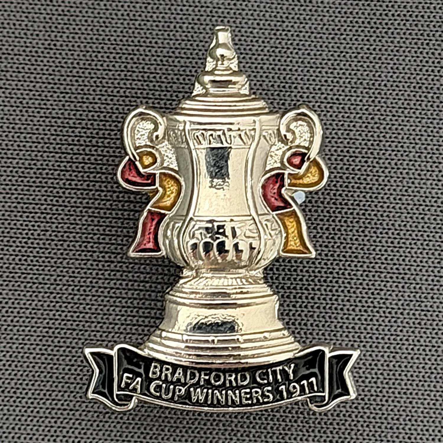 Reference Number: BCEVE034
Size: H 25.4 mm x W 18.2 mm
Pin Type: Brooch Pin
Plating: Silver
Value: £8
Manufacturer: Paraders
Comments: F.A. Cup Winner 1911, Claret Amber & Black