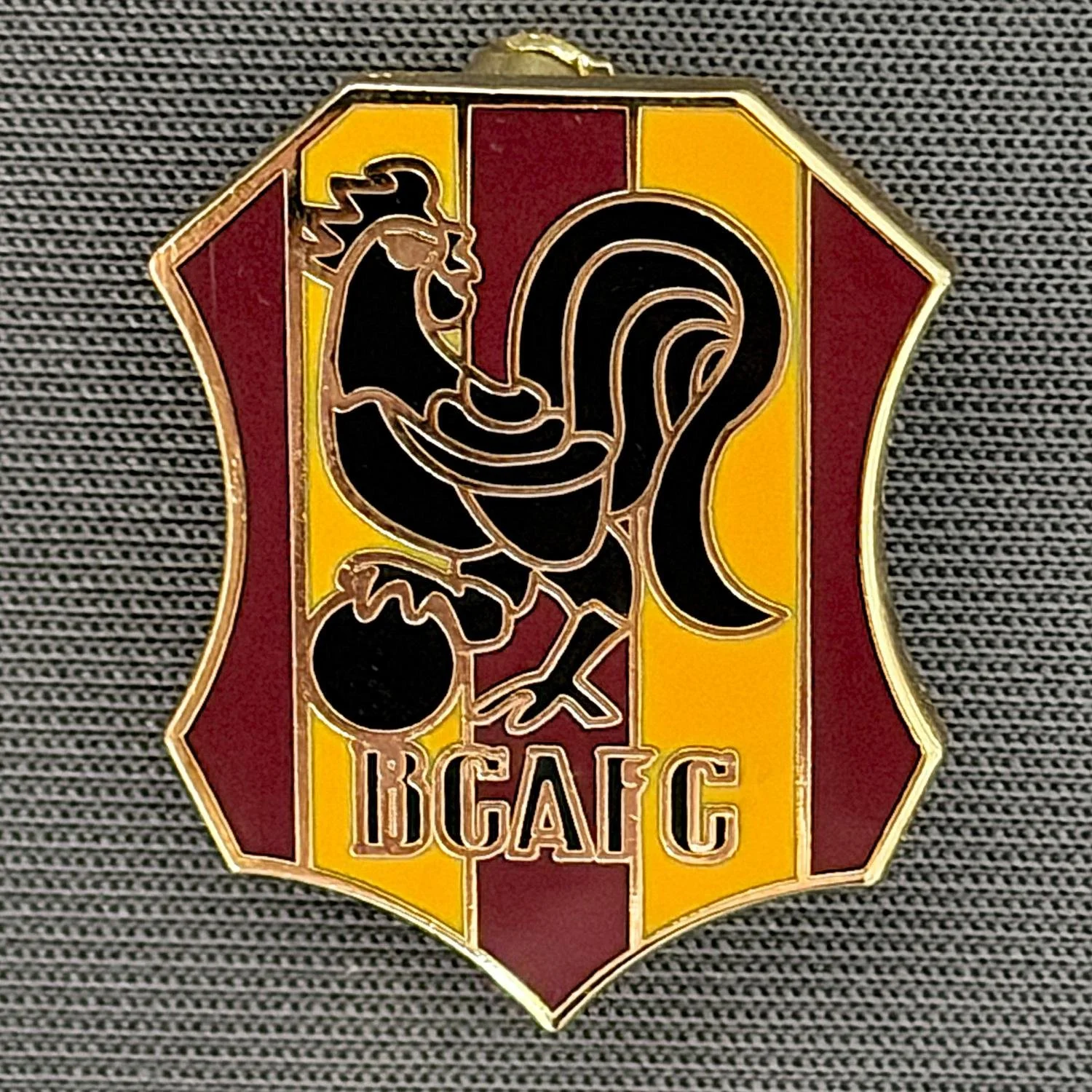 Reference Number: BCBAN046
Size: H 18 mm x W 14.1 mm
Pin Type: Brooch Pin
Plating: Gold
Value: £6
Manufacturer: Unknown
Comments: Amber, Claret & Black Bantam Shield