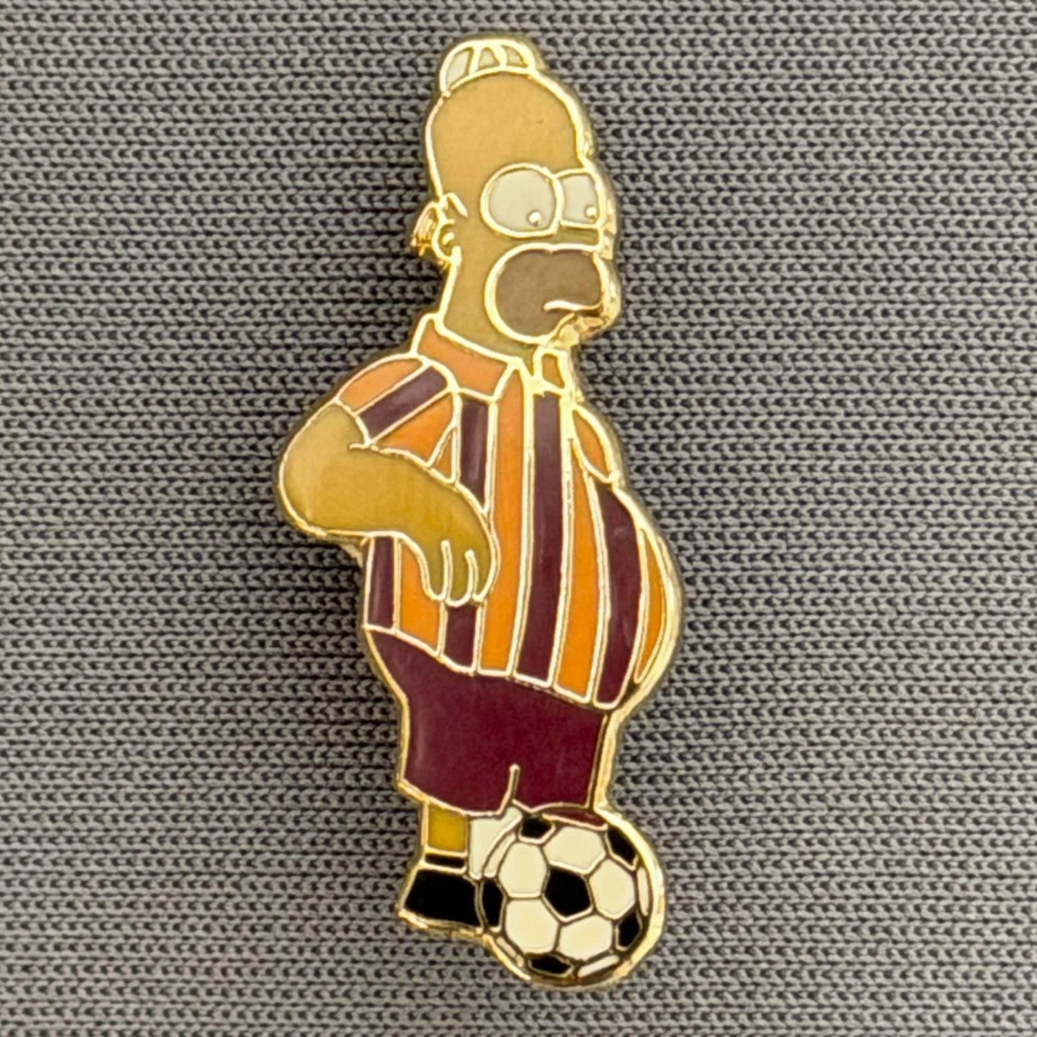Reference Number: BCCTN023
Size: H 25 mm x W 11.5 mm
Pin Type: Brooch Pin
Plating: Gold
Value: £6
Manufacturer: Not Known
Comments: Homer Simpson in Bradford City Kit