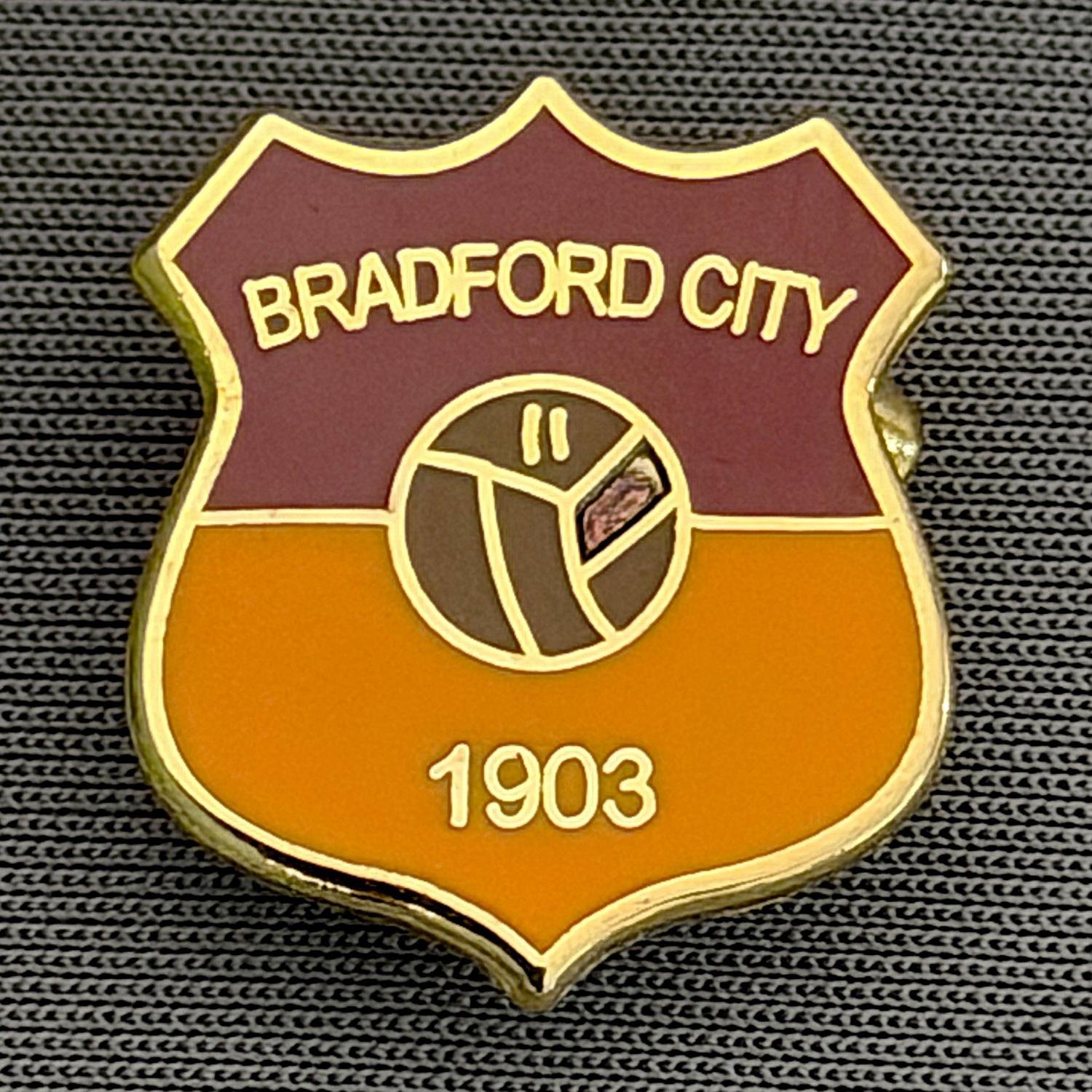 Reference Number: BCBCFC038
Size: H 20.1 mm x W 17.4 mm
Pin Type: Brooch Pin
Plating: Gold
Value: £6
Manufacturer: Unknown
Comments: Bradford City Claret & Amber Shield, Brown Ball, Small Version