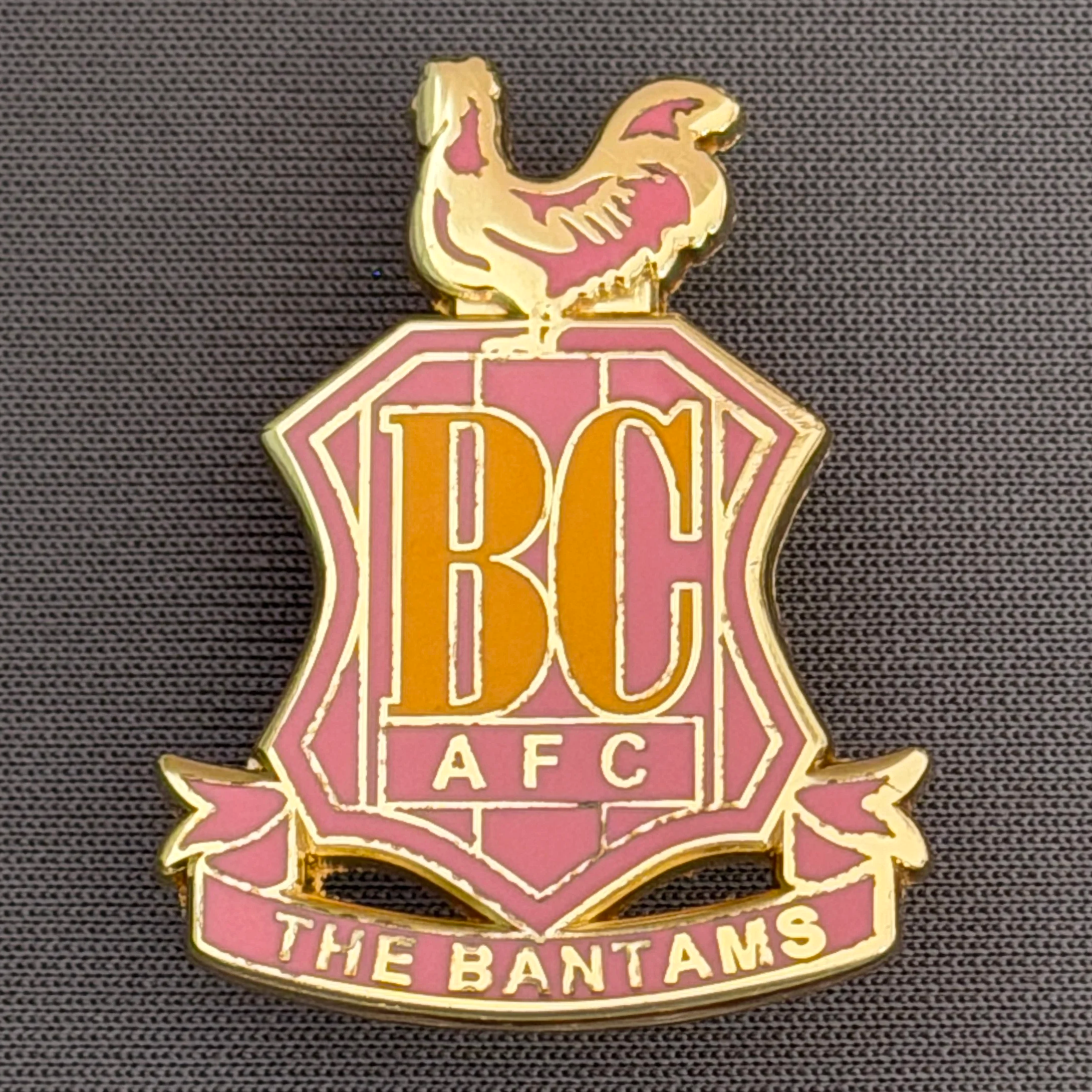Reference Number: BCC&L094
Size: H 32.9 mm x 25.5  mm
Pin Type: Brooch Pin
Plating: Gold
Value: £6
Manufacturer: Unknown
Comments: Classic BCAFC Logo Pink Version