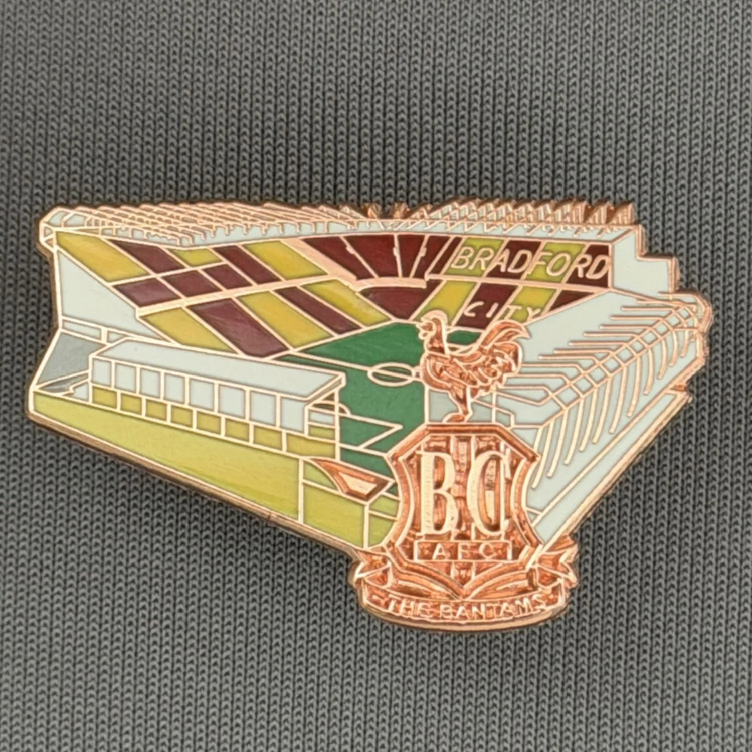Reference Number: BCVP026
Size: H 20.5 mm x W 32.1 mm
Pin Type: Metal Clutch
Plating: Nickel
Value: £4
Manufacturer: Dan Lloyd
Comments: Valley Parade Stadium with Metal City Logo