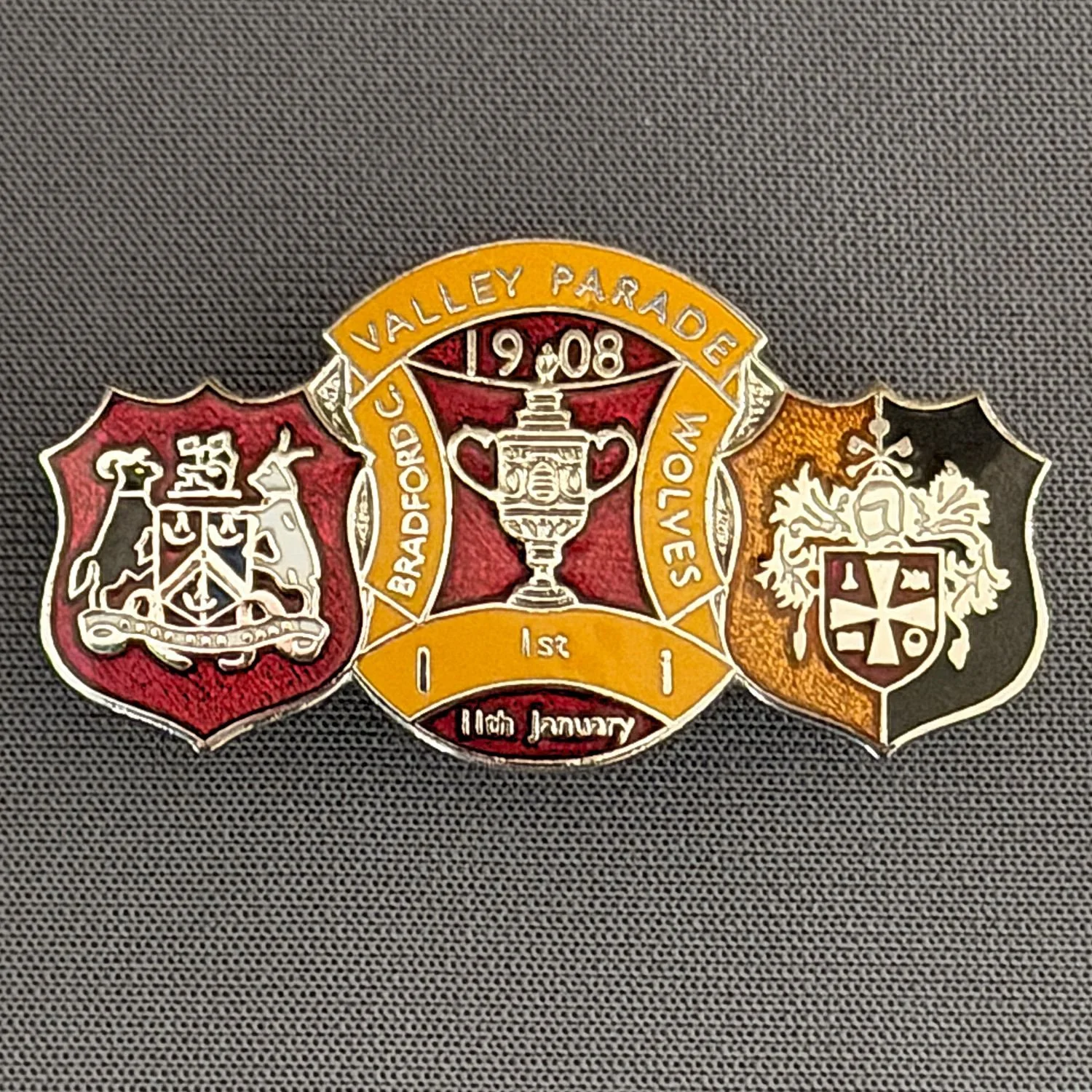 Reference Number: BCFAC157
Size: H 19.9 mm x W 37.1 mm
Pin Type: Double Metal Clutch
Plating: Silver
Value: £10
Manufacturer: AKP Designs
Comments: Bradford City v Wolves  F.A.Cup 1st Round Valley Parade, Claret & Amber Version