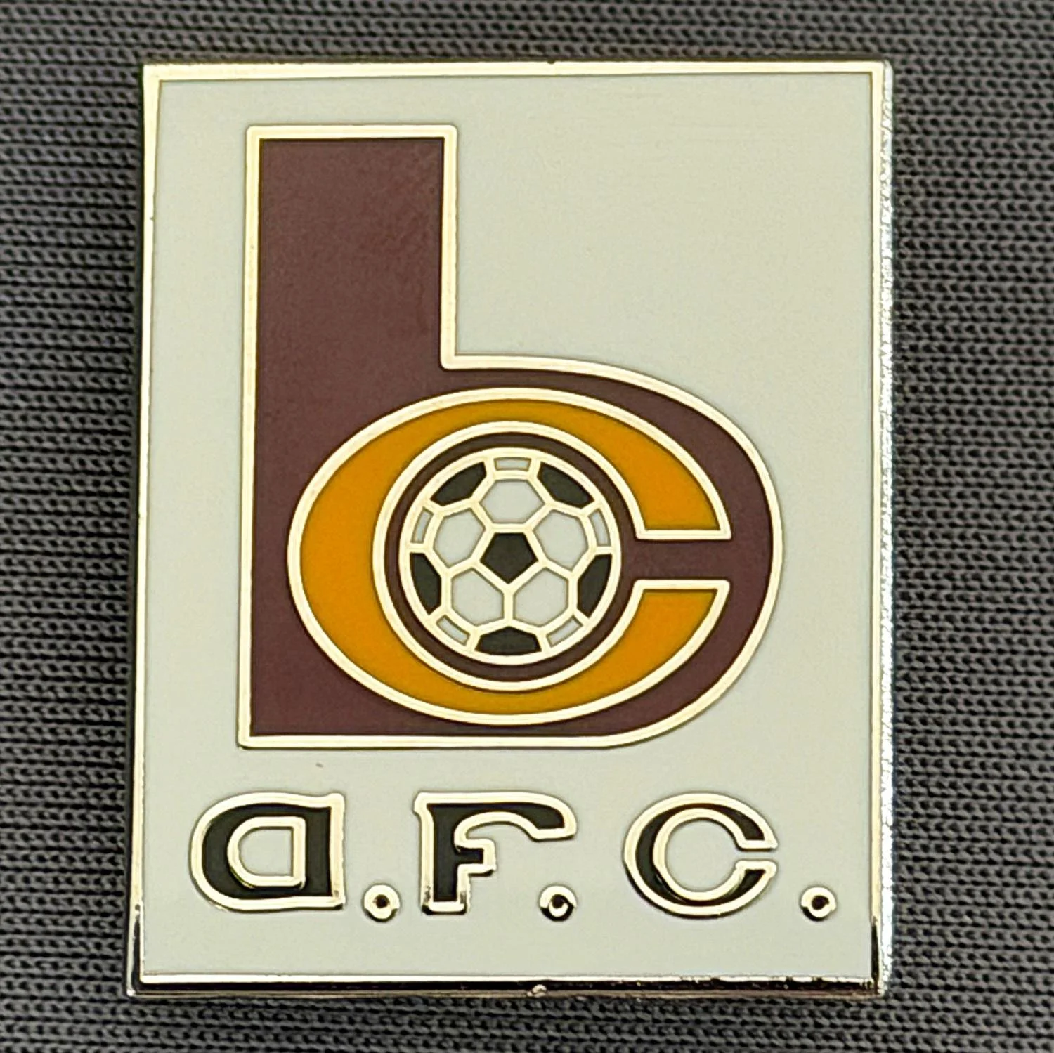 Reference Number: BCC&L148
Size: H 26 mm x 20.7 mm
Pin Type: Brooch Pin
Plating: Silver
Value: £6
Manufacturer: Unknown
Comments: Oblong White BC Logo, Different Amber Enamel