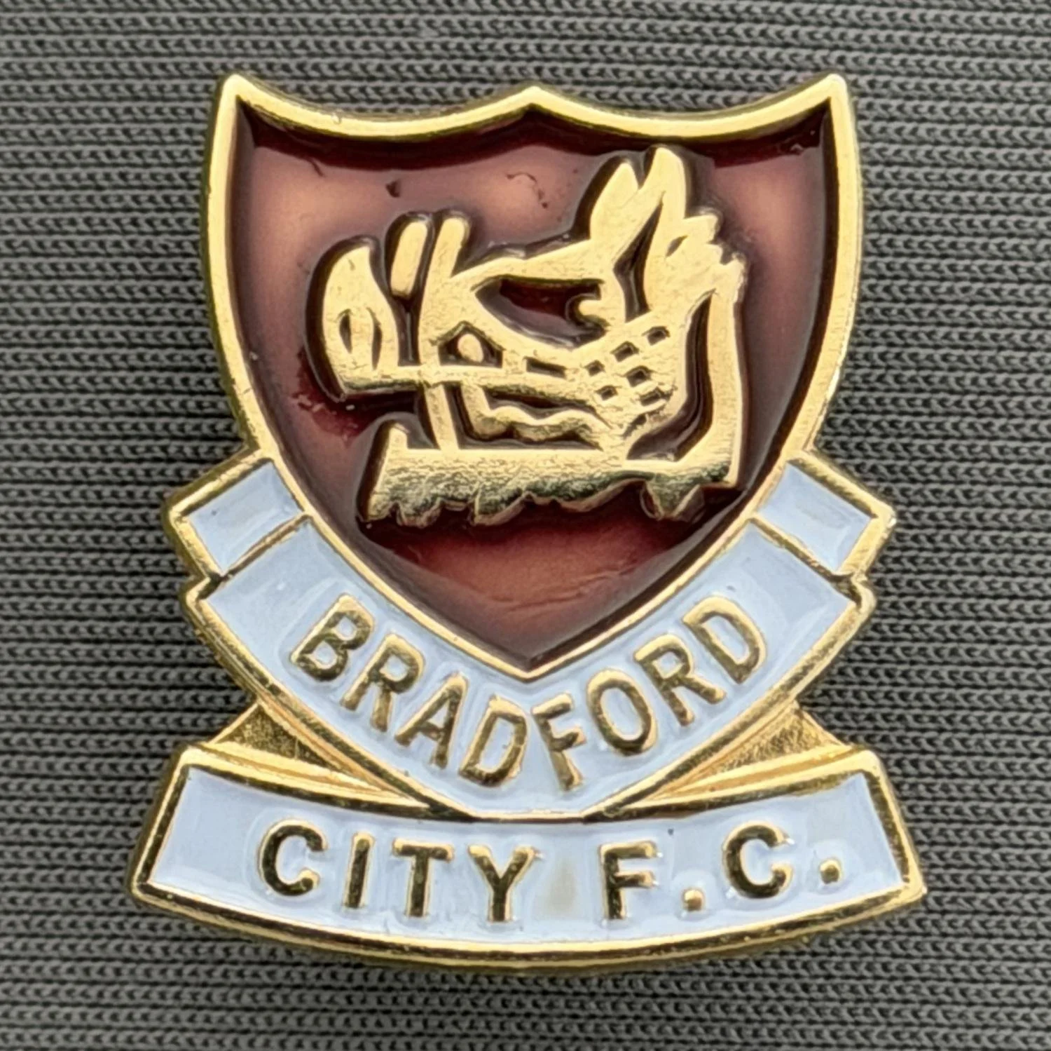 Reference Number: BCBOH057
Size: H 22.8 x W 20.4 mm
Pin Type: Brooch Pin
Plating: Gold
Value: £6
Manufacturer: Unknown
Comments: Claret & Blue Boar's Head Shield