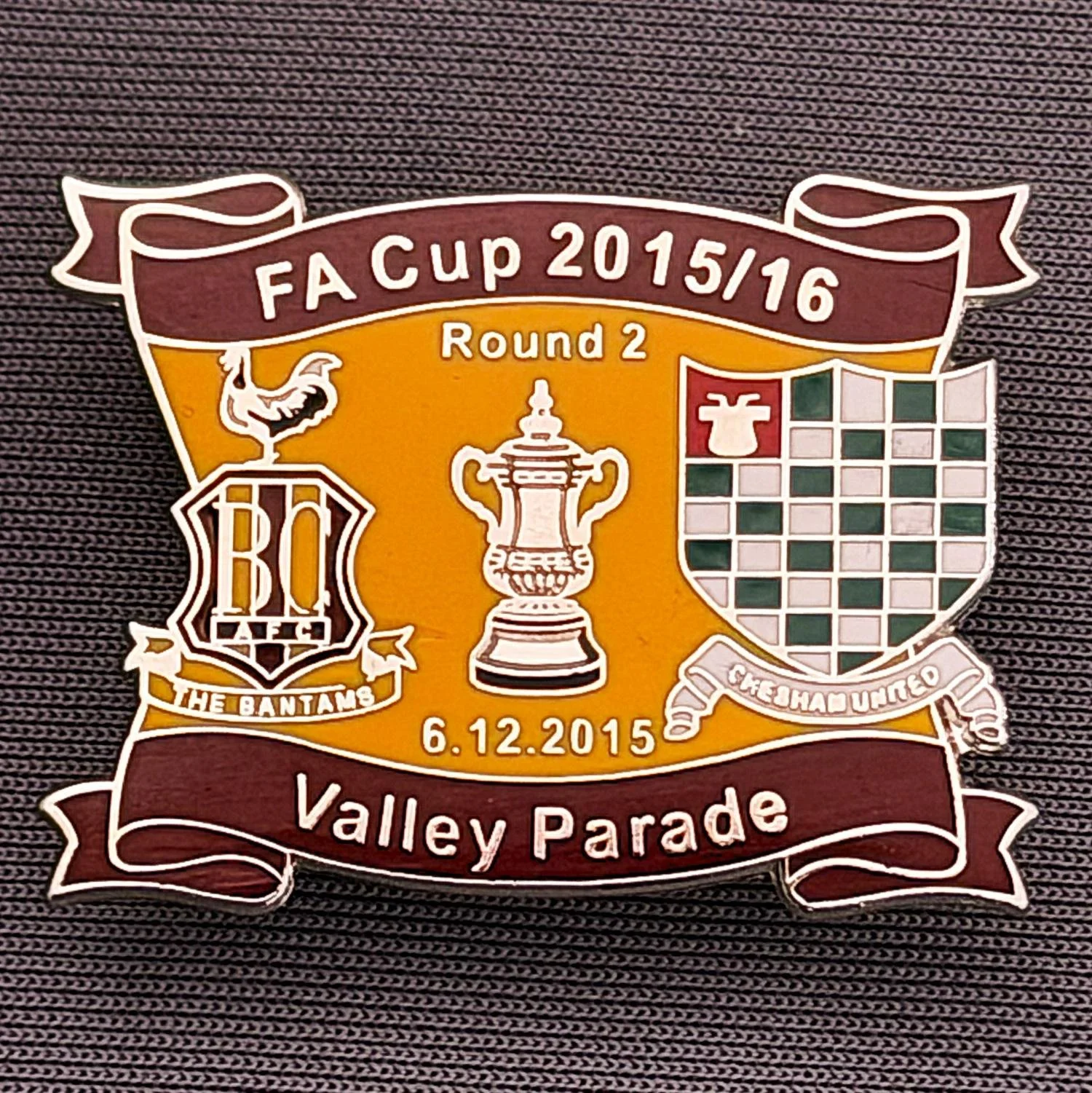 Reference Number: BCFAC138
Size: H 24.5 mm x W 32.5 mm
Pin Type: Metal Clutch
Plating: Silver
Value: £4
Manufacturer: Dan Lloyd
Comments: F.A. Cup Second Round 2015/16 v Chesham United, Claret & Amber Version