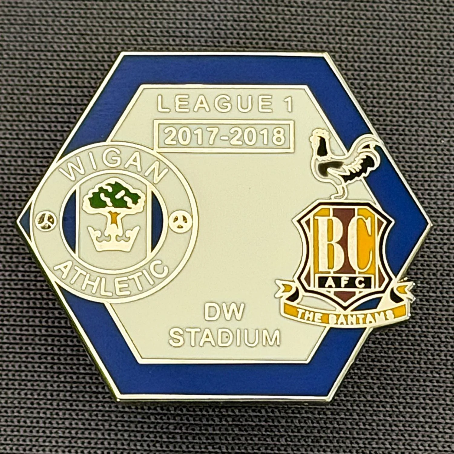 Reference Number: BCOFIX121
Size: H 21.6 mm x W 24.8 mm
Pin Type: Metal Clutch
Plating: Silver
Value: £5
Manufacturer: Unknown
Comments: Wigan v Bradford City, League One 2017/18, Blue & White Version 
