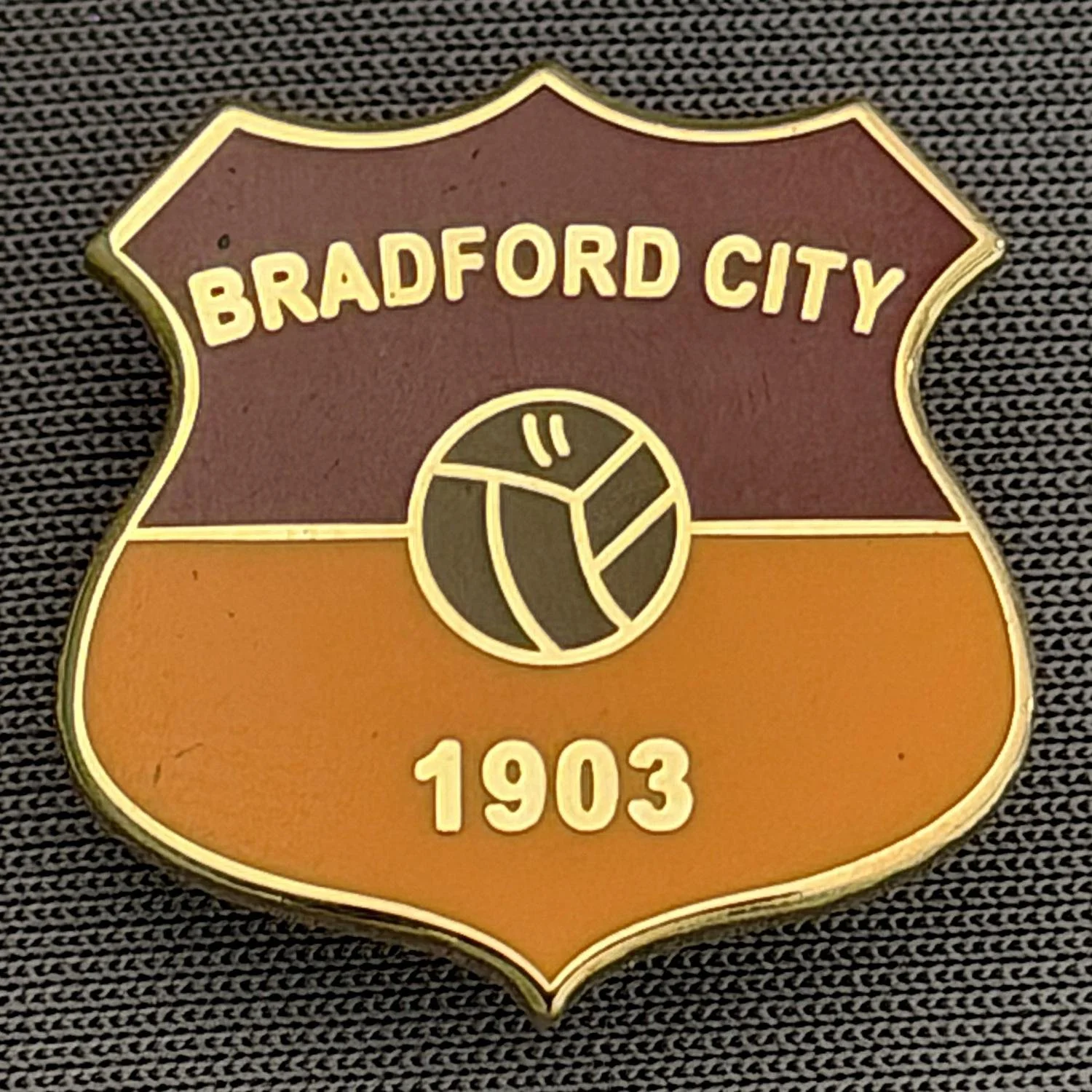 Reference Number: BCBCFC040
Size: H 20.9 mm x W 20.8 mm
Pin Type: Brooch Pin
Plating: Gold
Value: £6
Manufacturer: Unknown
Comments: Bradford City Claret & Amber Shield, Brown Ball, Large Version