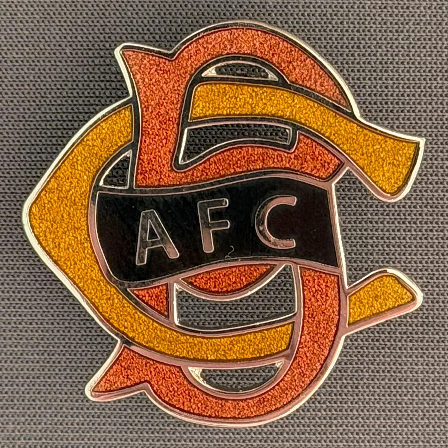 Reference Number: BCC&L059
Size: H 30 mm x 30 mm
Pin Type: Brooch Pin
Plating: Silver
Value: £8
Manufacturer: Paraders
Comments: BCAFC Ayrton Scroll Claret & Amber Cloisonne, Black