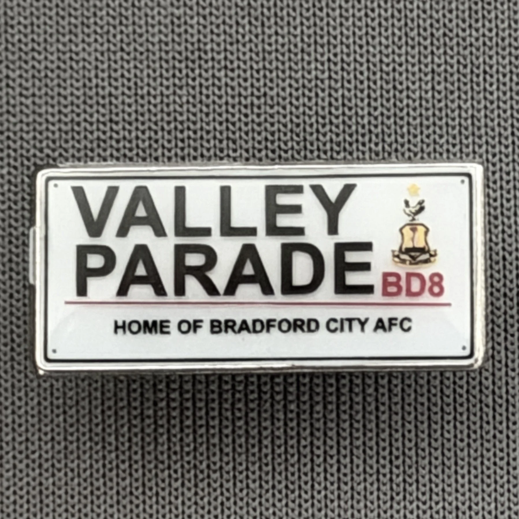 Reference Number: BCVP013
Size: H 9.4 mm x W 20.3 mm
Pin Type: Metal Clutch
Plating: Silver
Value: £6
Manufacturer: Bradford City Shop
Comments: Tiny Valley Parade Sign