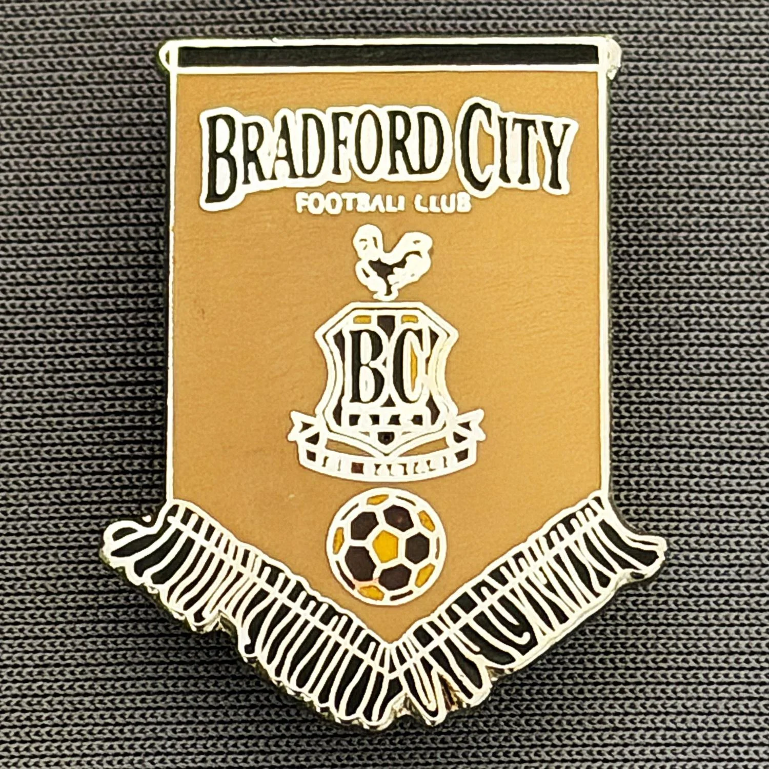Reference Number: BCBCFC063
Size: H 28.1 mm x W 22.1 mm
Pin Type: Brooch Pin
Plating: Gold
Value: £6
Manufacturer: Andy Stokes
Comments: Coffee & Black Bradford City Pennant