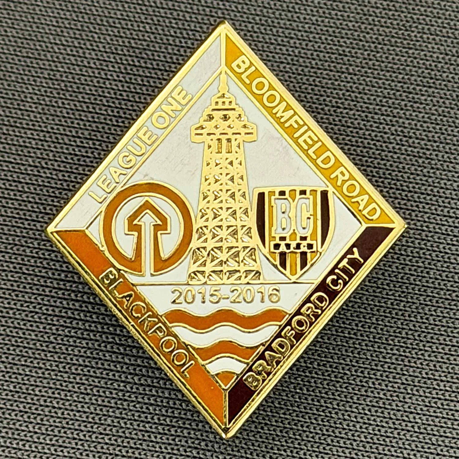 Reference Number: BCOFIX156
Size: H 26.2 mm x W 22.5 mm
Pin Type: Rubber Clutch
Plating: Gold
Value: £6
Manufacturer: Unknown
Comments: Blackpool v Bradford City League One 2015/16 Tangerine, Claret & Amber Version, Limited Edition 30