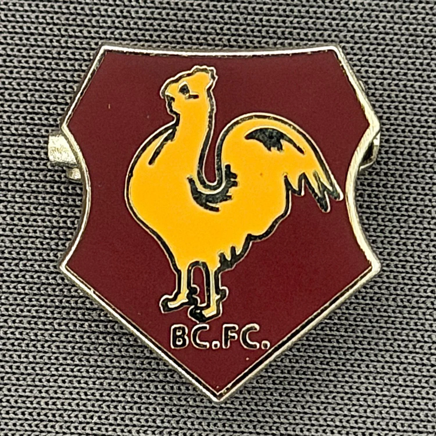 Reference Number: BCBAN056
Size: H 18.6 mm x W 16.6 mm
Pin Type: Brooch Pin
Plating: Silver
Value: £6
Manufacturer: Unknown
Comments: Claret & Amber, Bantam Crest Shield 