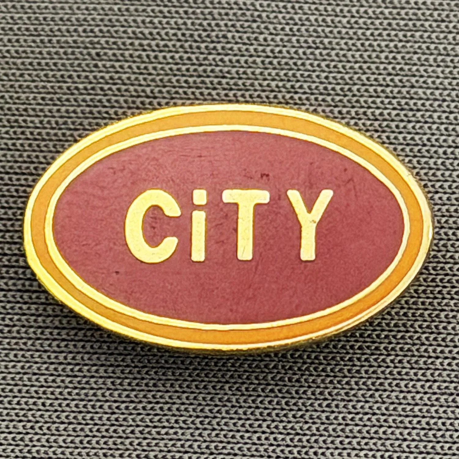 Reference Number: BCBCFC024
Size: H 12.3 mm x W 19.9 mm
Pin Type: Brooch Pin
Plating: Gold
Value: £6
Manufacturer: Unknown
Comments: Oval City, Claret Version