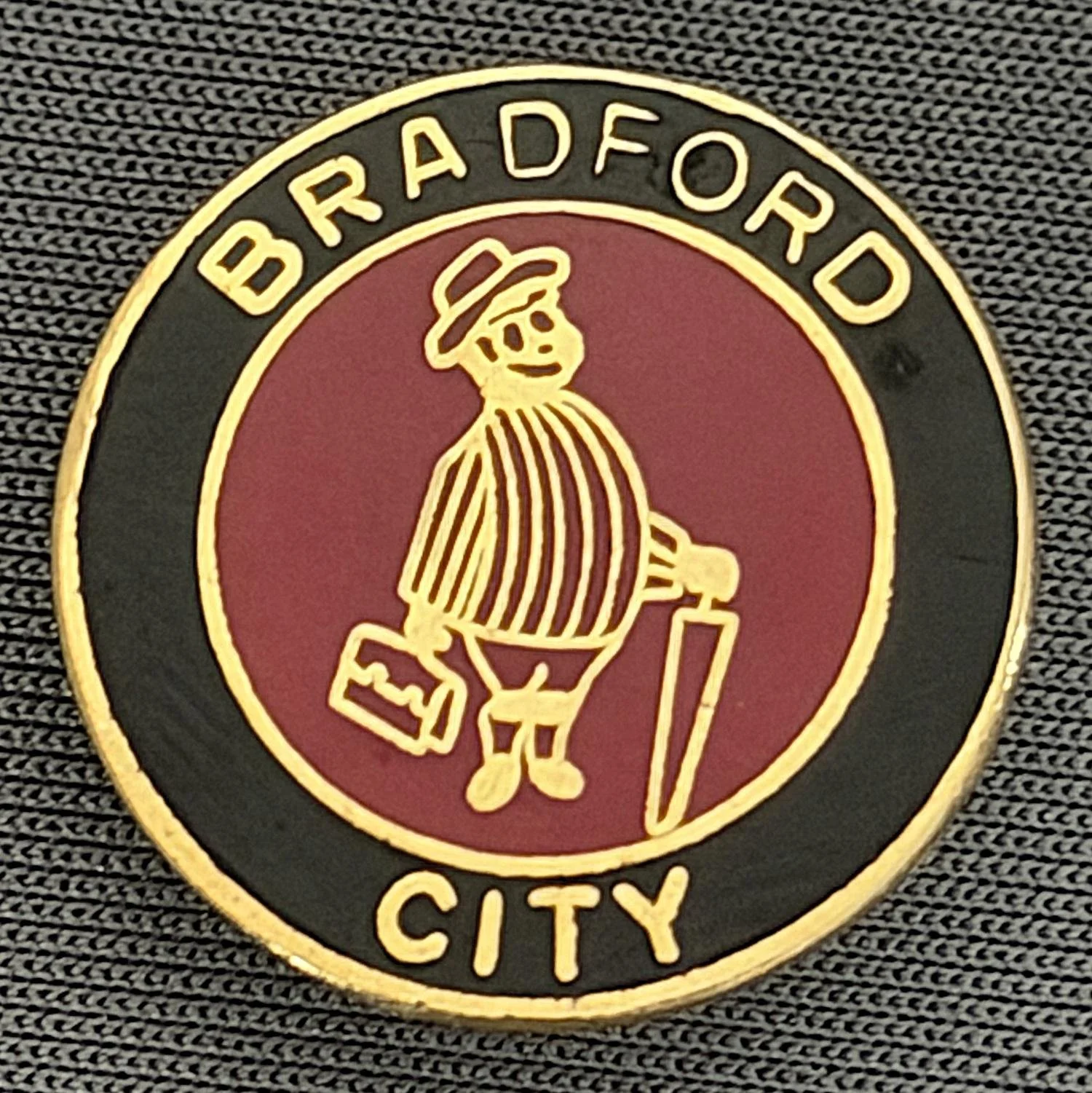 Reference Number: BCGEN022
Size: D 20 mm
Pin Type: Brooch Pin
Plating: Gold
Value: £8
Manufacturer: Unknown
Comments: Circular Black & Claret City Gent
