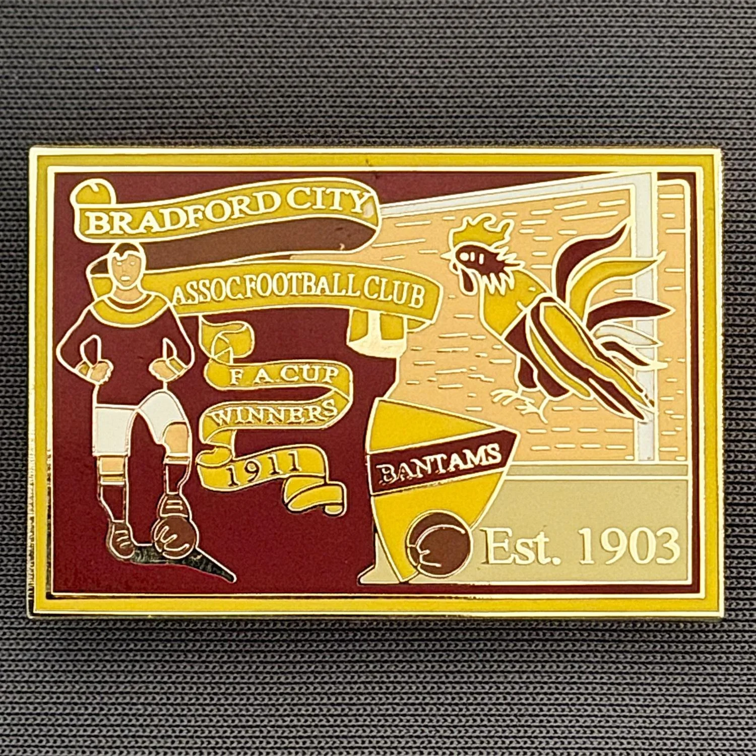 Reference Number: BCFAC025
Size: H 26.4 mm x W 38.4 mm
Pin Type: Double Metal Clutch
Plating: Gold
Value: £6
Manufacturer: Unknown
Comments: Bradford City Cup Winners 1911, Claret & Amber Version