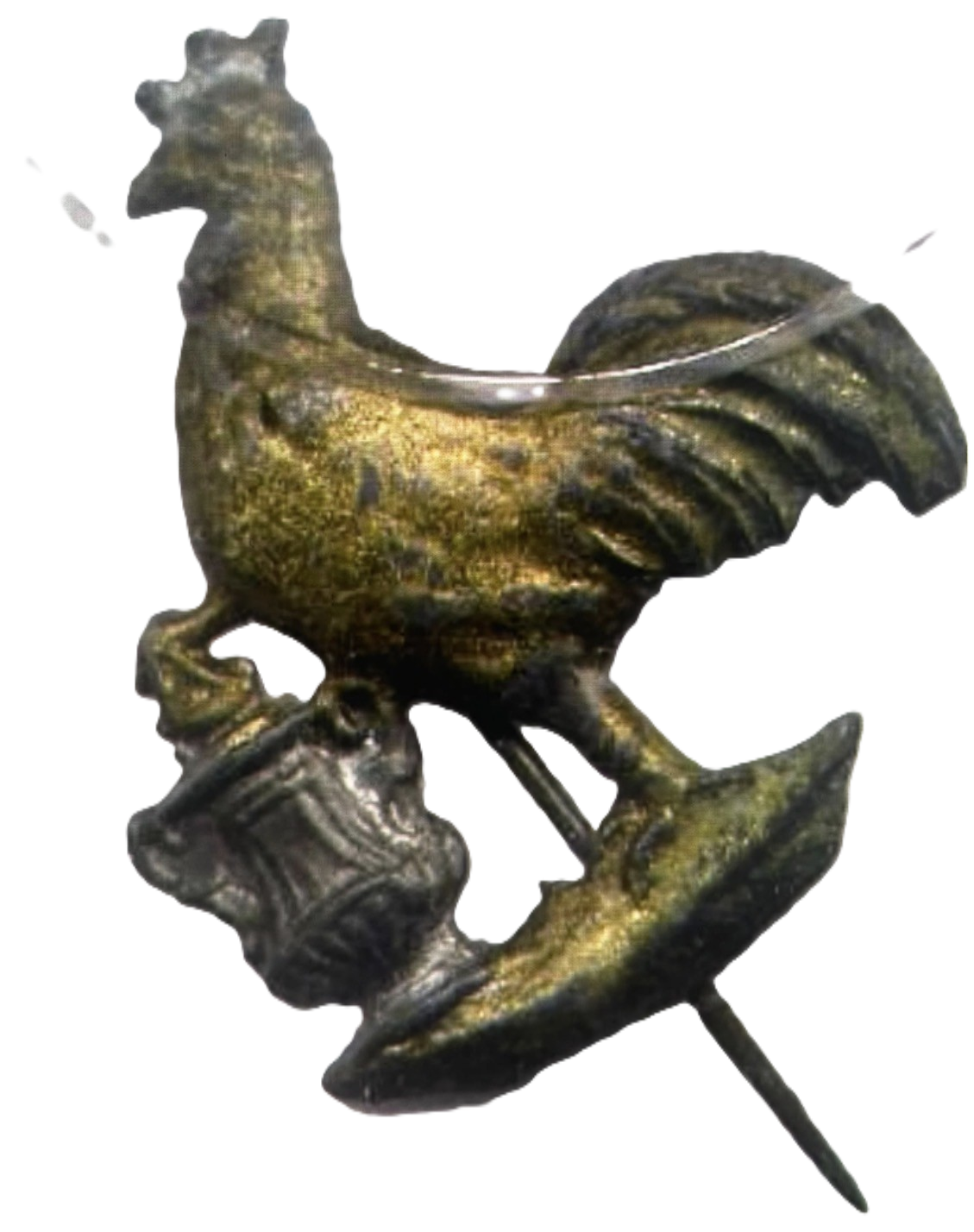 A metallic pin in the shape of a phoenix with its wings spread, perched on a branch.