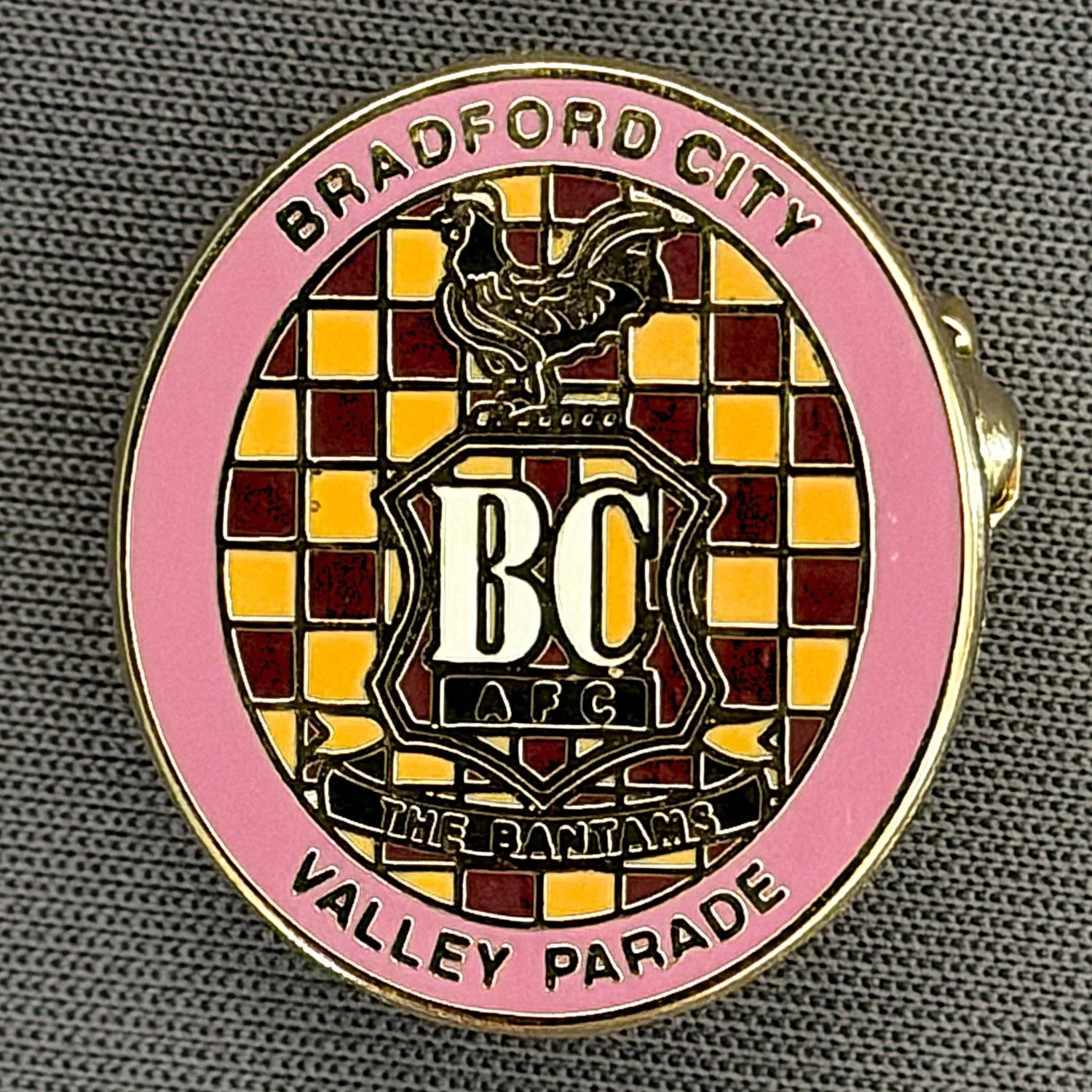 Reference Number: BCC&L101
Size: H 22.6 mm x 20.3  mm
Pin Type: Brooch Pin
Plating: Gold
Value: £6
Manufacturer: Unknown
Comments: Oval Pink Check City Crest