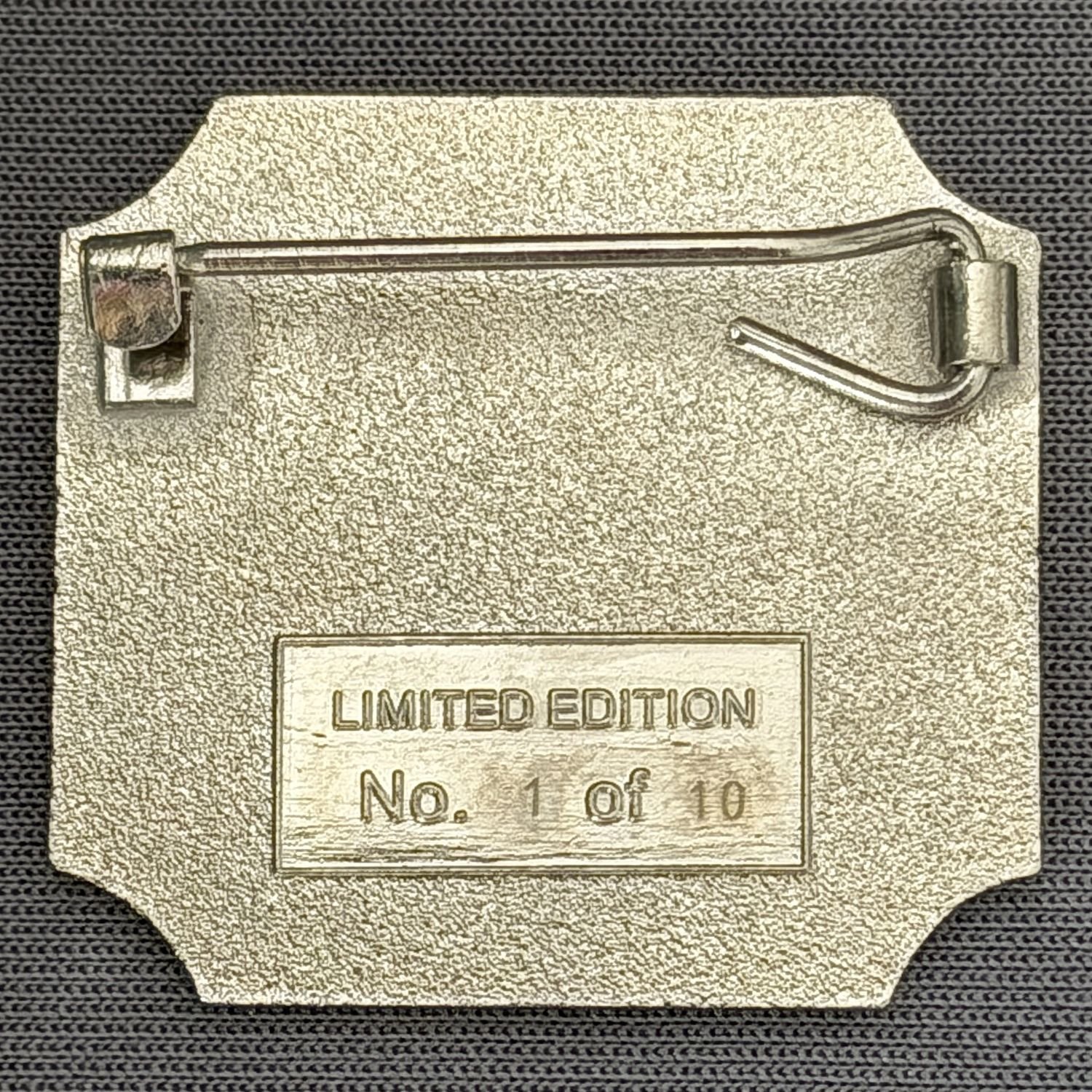 Close-up of a metallic badge with the words "Limited Edition" and a number, attached to a fabric with a pin.