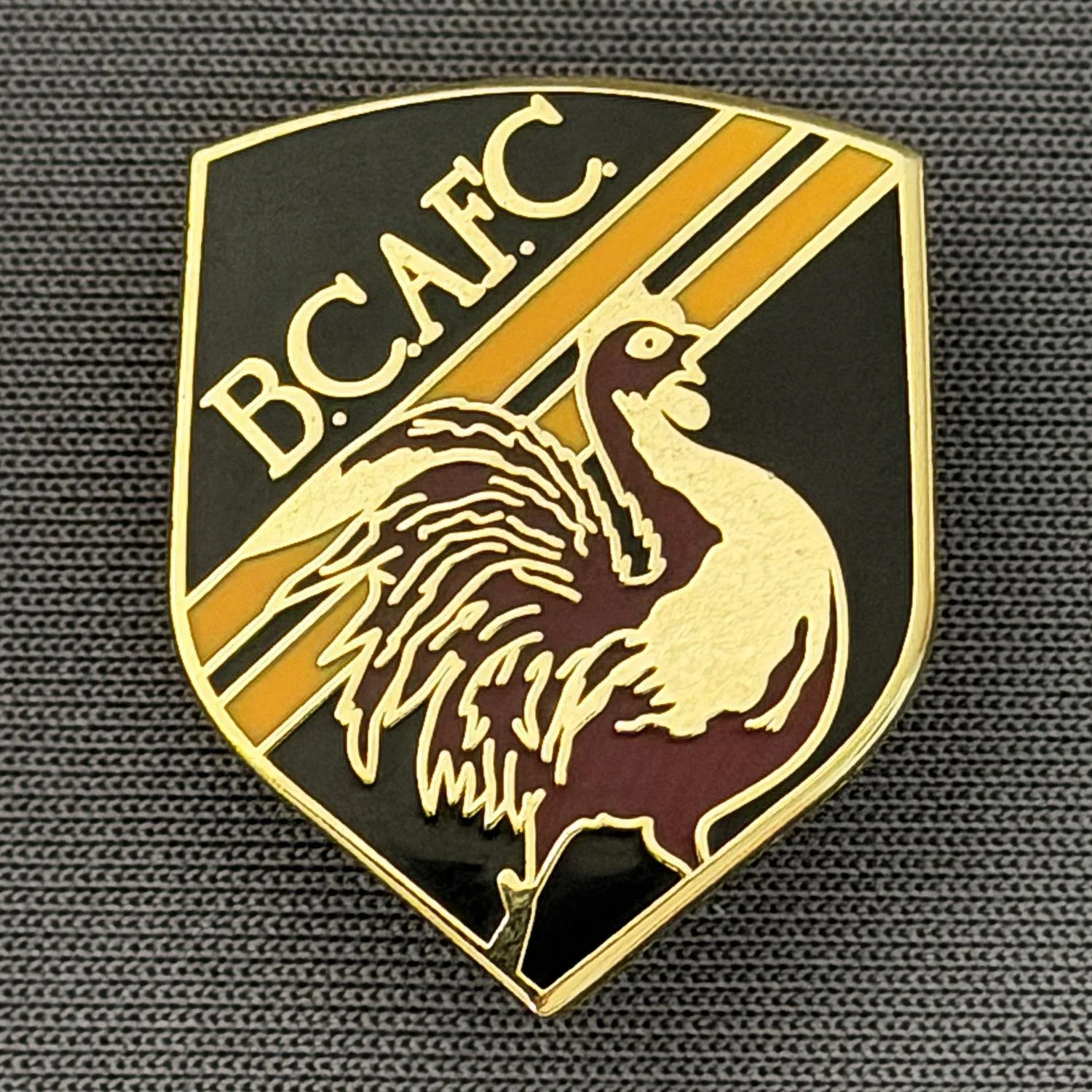 Reference Number: BCBAN049
Size: H 24.1 mm x W 19.4. mm
Pin Type: Brooch Pin
Plating: Gold
Value: £6
Manufacturer: Unknown
Comments: Black, Claret & Amber Bantam Shield