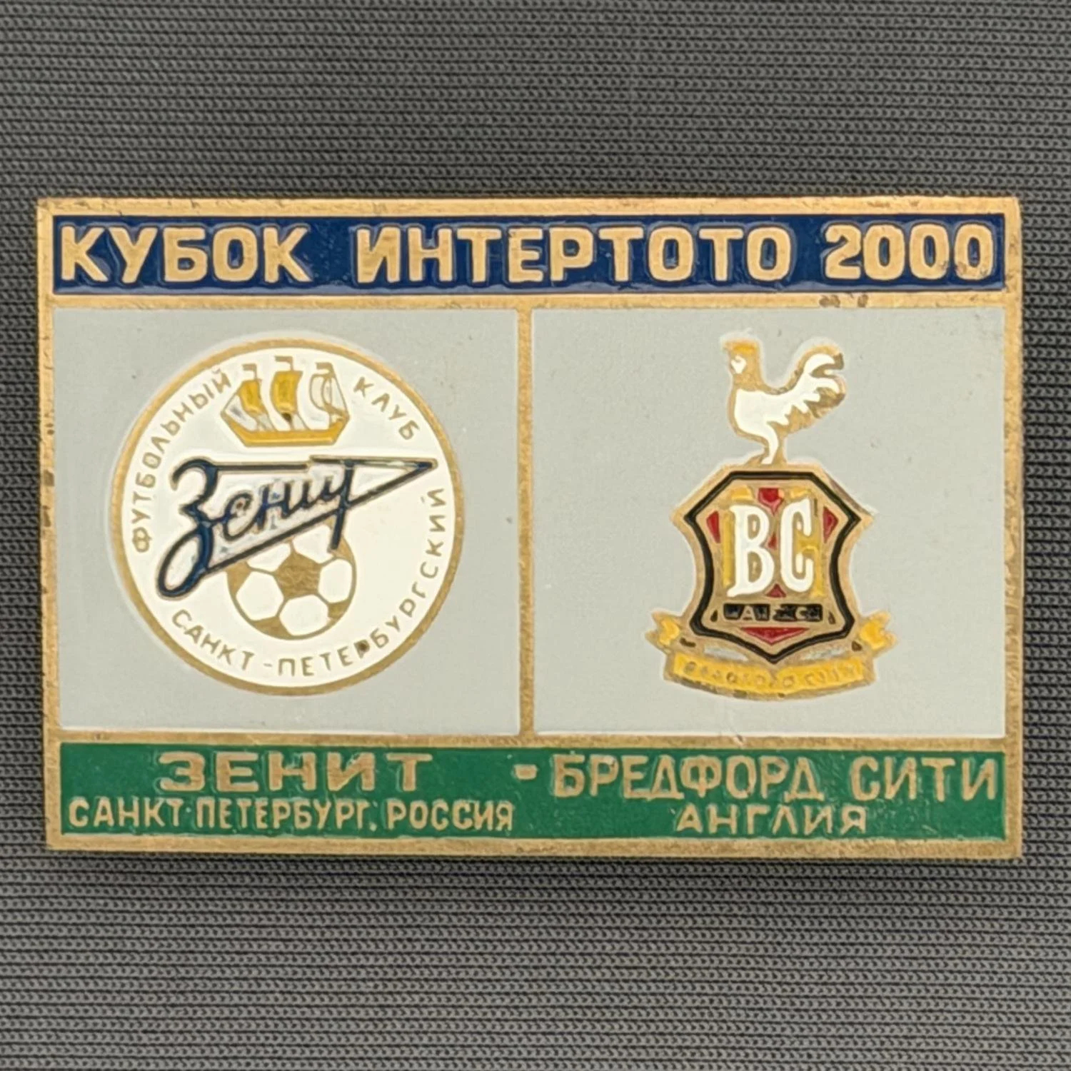 Reference Number: BCRUS018
Size: H 29.6 mm x W 44.6 mm
Pin Type: Metal Clutch
Plating: Antique Gold
Value: £12
Manufacturer: Unknown
Comments: Zenit St. Petersburg Inter Toto Cup, Blue Top, Grey Middle, Green Bottom