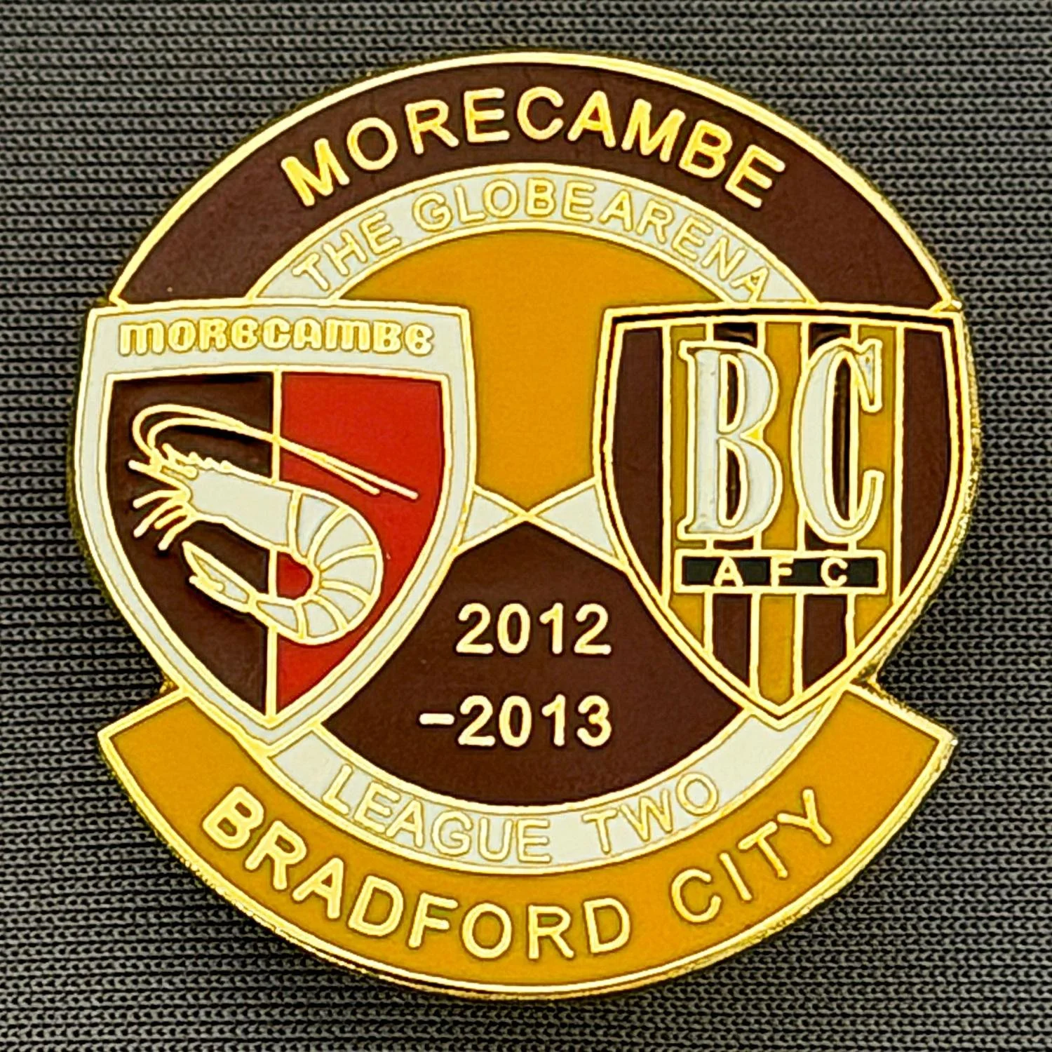 Reference Number: BCOFIX140
Size: H 32.4 mm x W 30.5 mm
Pin Type: Double Rubber Clutch
Plating: Gold
Value: £5
Manufacturer: Unknown
Comments: Morecambe v Bradford City  League Two 2012/13, Claret & Amber Version 