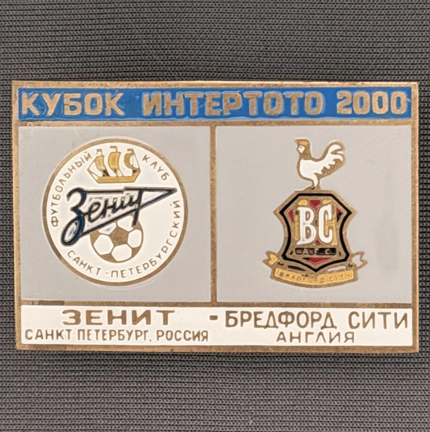 Reference Number: BCRUS016
Size: H 29.6 mm x W 44.6 mm
Pin Type: Metal Clutch
Plating: Antique Gold
Value: £12
Manufacturer: Unknown
Comments: Zenit St. Petersburg Inter Toto Cup, Mid Blue Top, Grey Middle, White Bottom