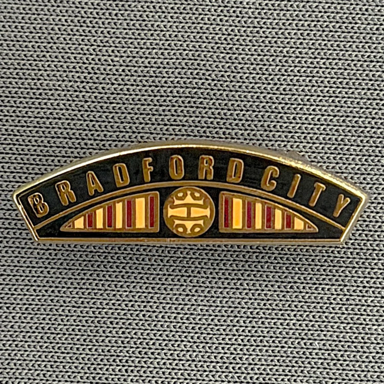 Reference Number: BCBCFC059
Size: H 6.6 mm x W 22.6 mm
Pin Type: Brooch Pin
Plating: Gold
Value: £6
Manufacturer: Unknown
Comments: Bradford City Black Railway Engine Nameplate 
