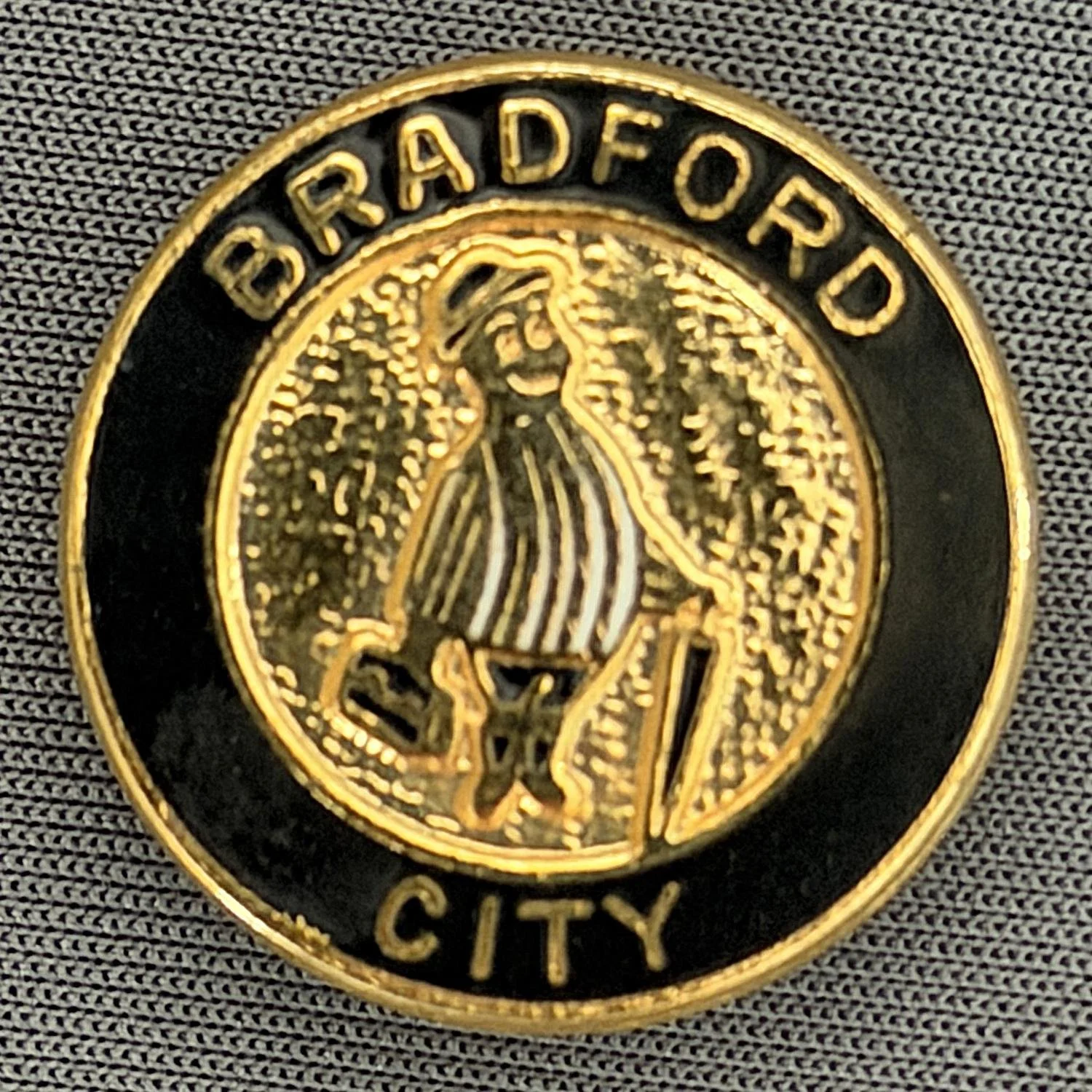 Reference Number: BCGEN018
Size: D 25.3 mm
Pin Type: Brooch Pin
Plating: Gold
Value: £10
Manufacturer: Unknown
Comments: Circular City Poor Quality Gent, Black Version, White Stripe Shirt