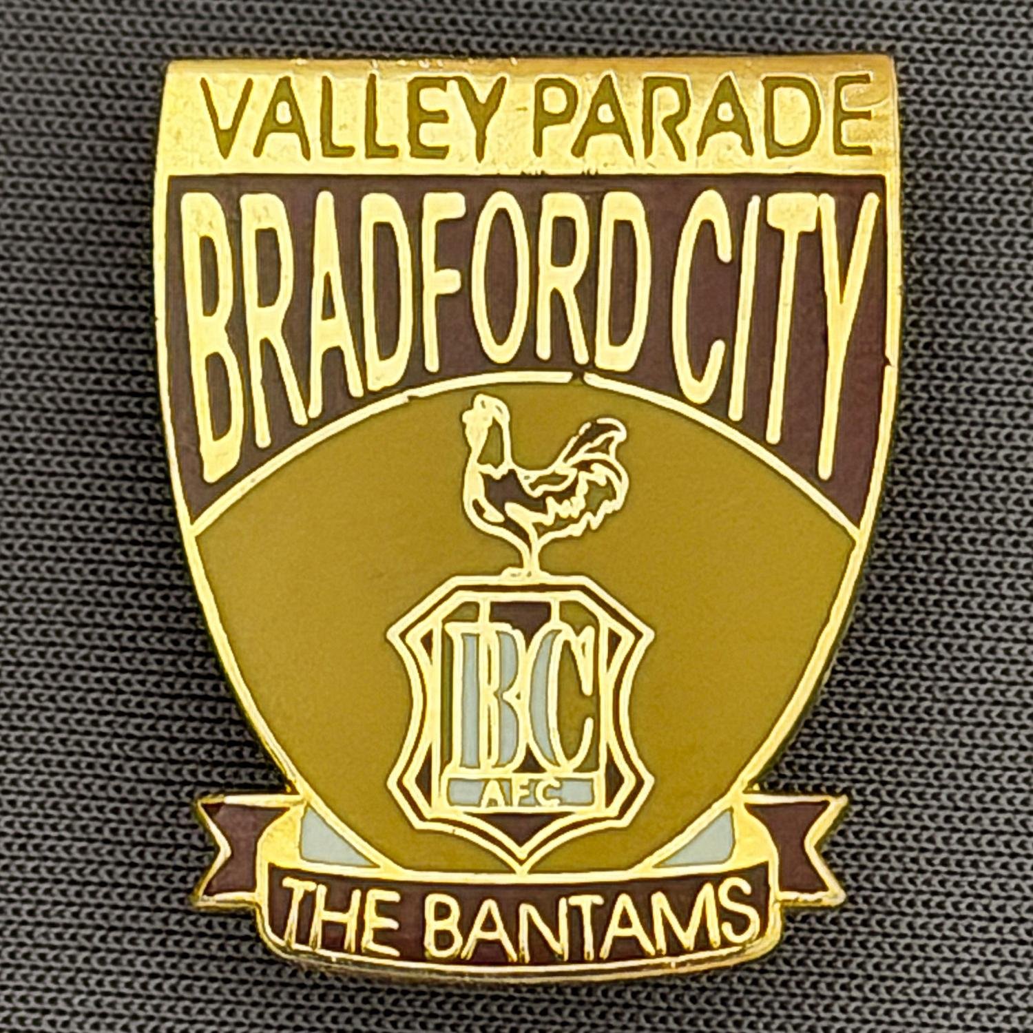 Reference Number: BCC&L026
Size: H 25.4 mm x W 20.3 mm
Pin Type: Brooch Pin
Plating: Gold
Value: £8
Manufacturer: Unknown
Comments: Valley Parade City Logo Shield