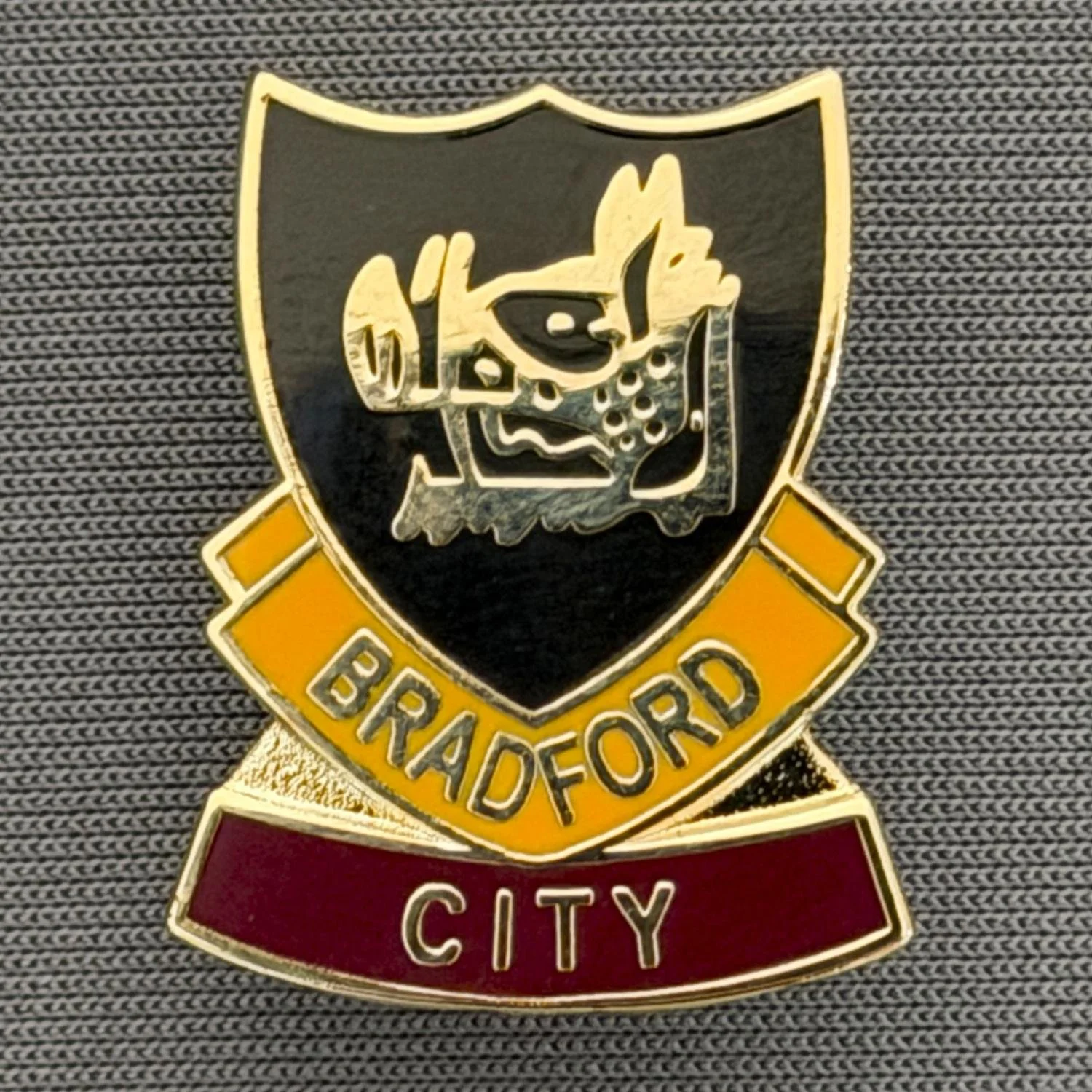 Reference Number: BCBOH061
Size: H 23.8 x W 19.1 mm
Pin Type: Brooch Pin
Plating: Gold
Value: £6
Manufacturer: Unknown
Comments: Black, Amber & Claret Boar's Head Shield