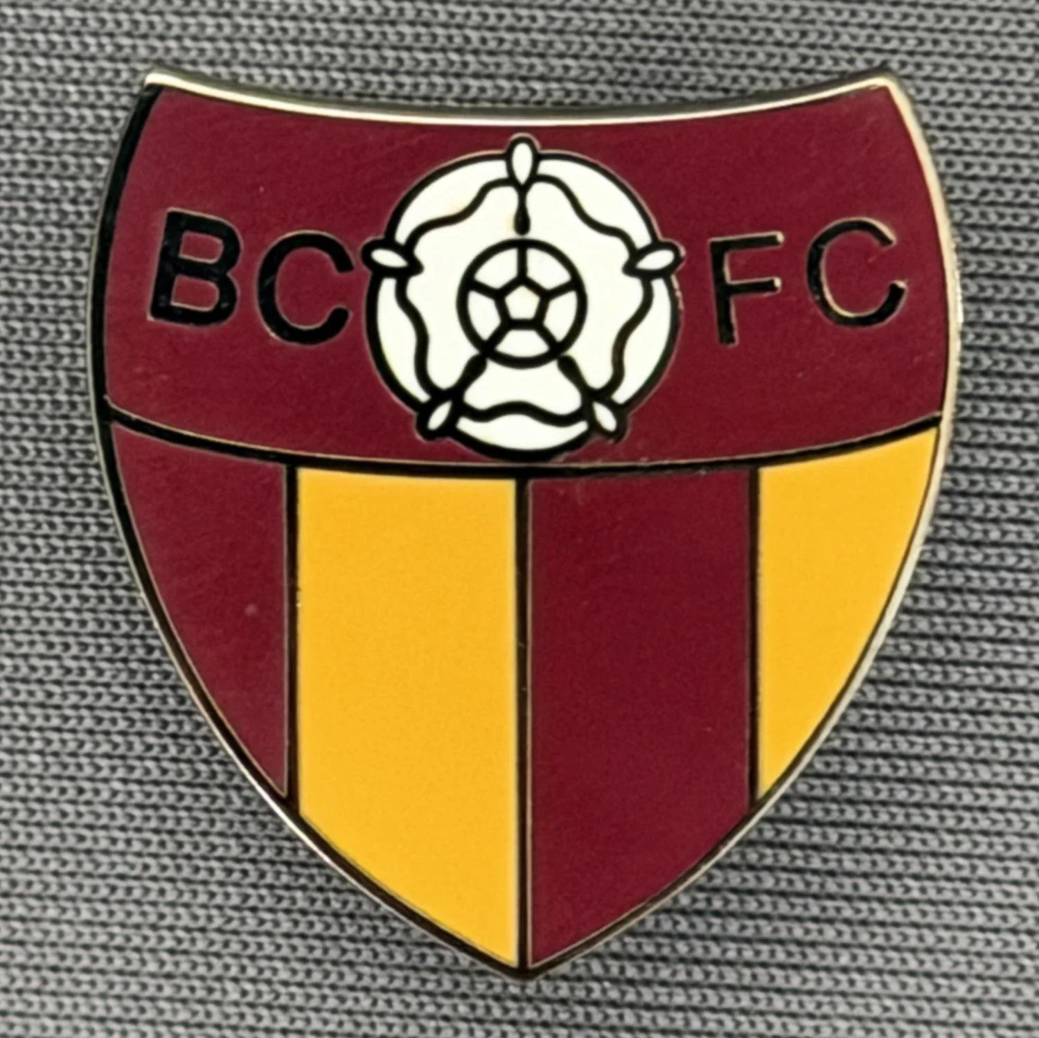 Reference Number: BCYR025
Size: H 22.8 mm x W 21.2 mm
Pin Type: Brooch Pin
Plating: Black Nickel
Value: £8
Manufacturer: Unknown
Comments: BCFC Yorkshire Rose Claret & Amber Shield. Smaller version.