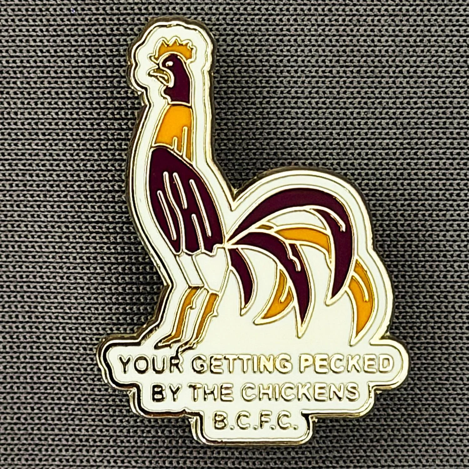 Reference Number: BCBAN064
Size: H 24.7 mm x W 17.9 mm
Pin Type: Brooch Pin
Plating: Silver
Value: £6
Manufacturer: Unknown
Comments: White, Claret & Amber Bantam, Pecked By The Chickens 