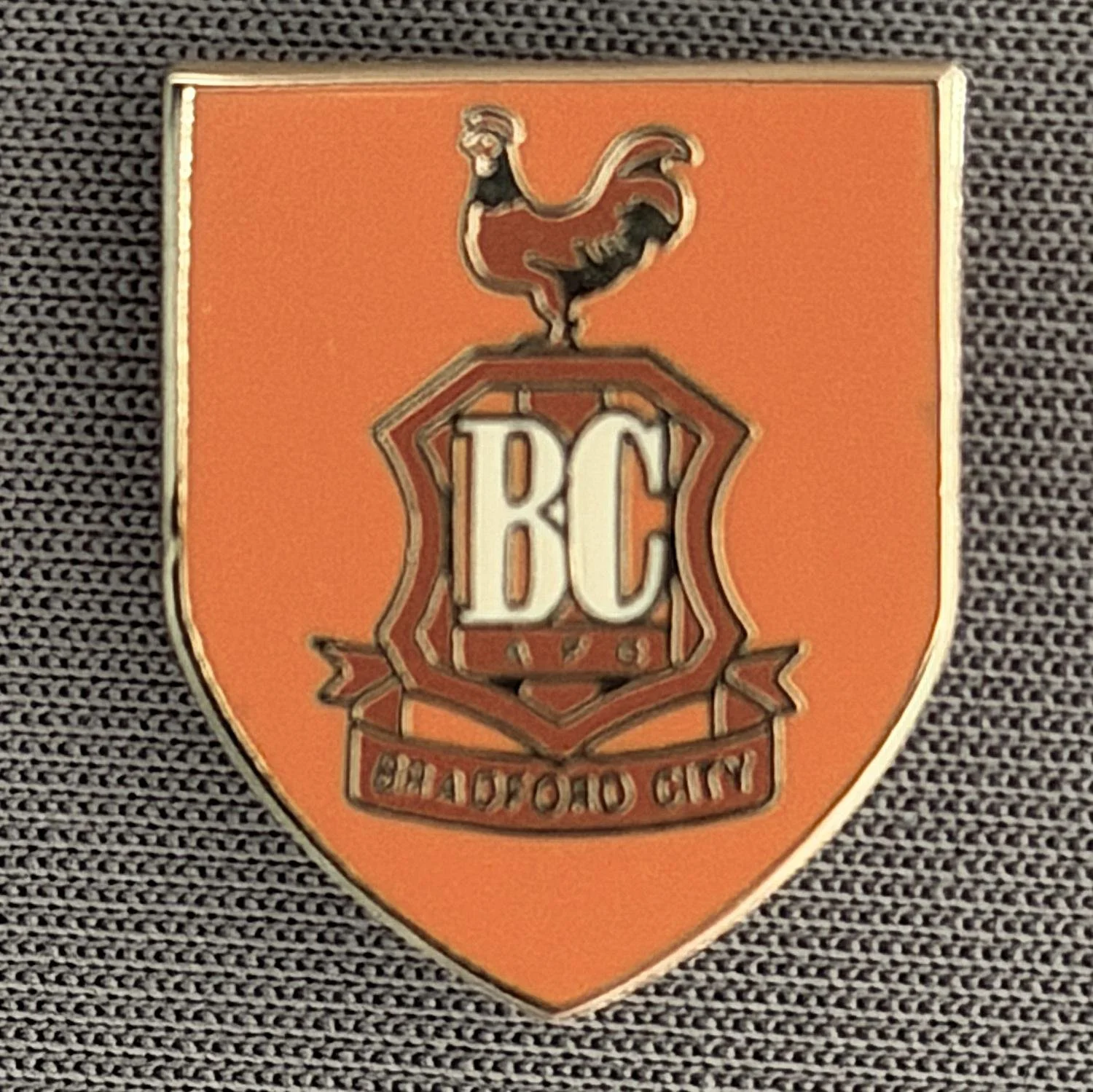 Reference Number: BCC&L024
Size: H 19 mm x W 15.6 mm
Pin Type: Brooch Pin
Plating: Gold
Value: £6
Manufacturer: Unknown
Comments: Darker Amber City Logo Shield