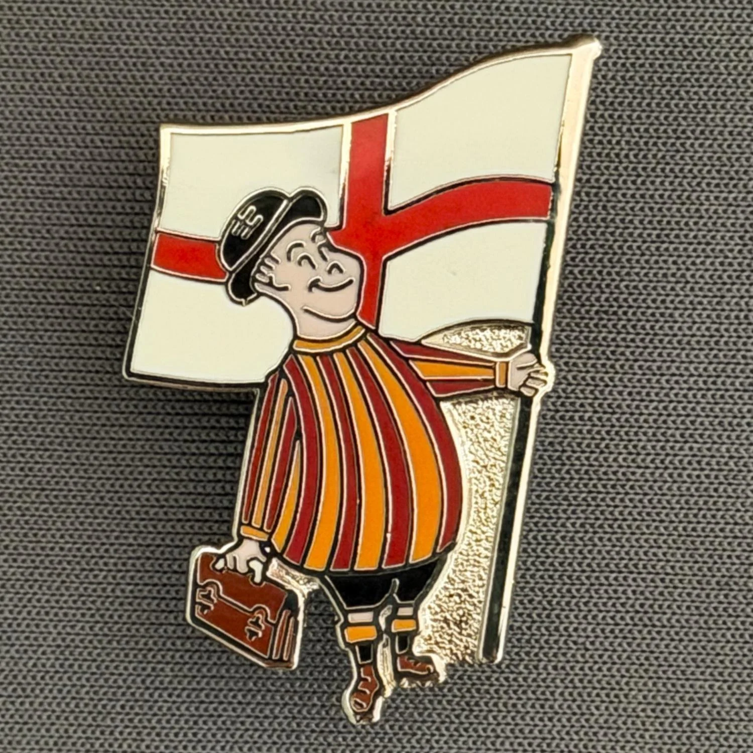 Reference Number: BCFLA025
Size: H 32 mm x W 19 mm
Pin Type: Brooch Pin
Plating: Silver
Value: £8
Manufacturer: Paraders
Comments: City Gent with St George Flag