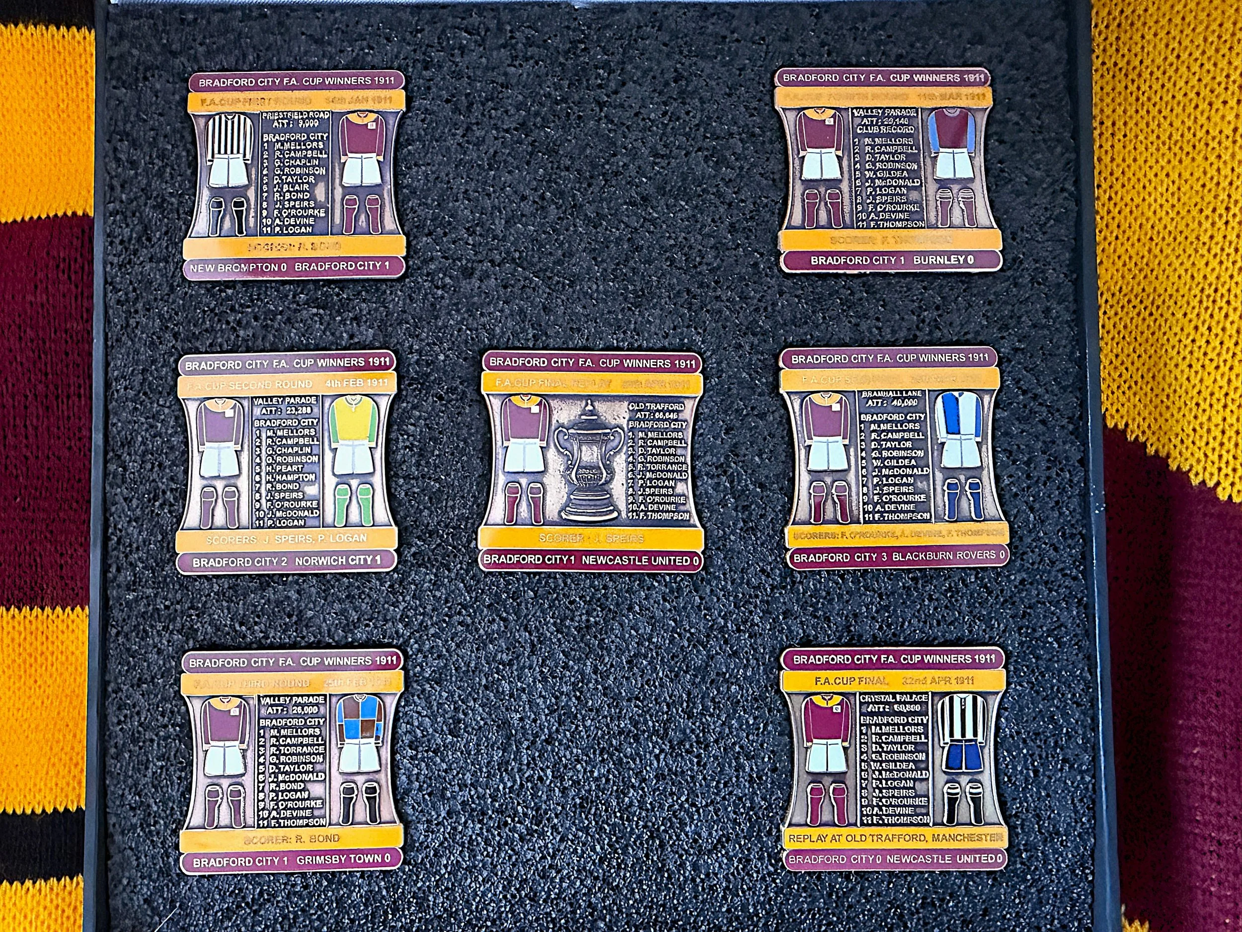 Collection of vintage football match tickets from Bradford City matches in 1911. The tickets are colorful with illustrations of players and match details, laid out on a dark textured surface with yellow, red, and black borders.